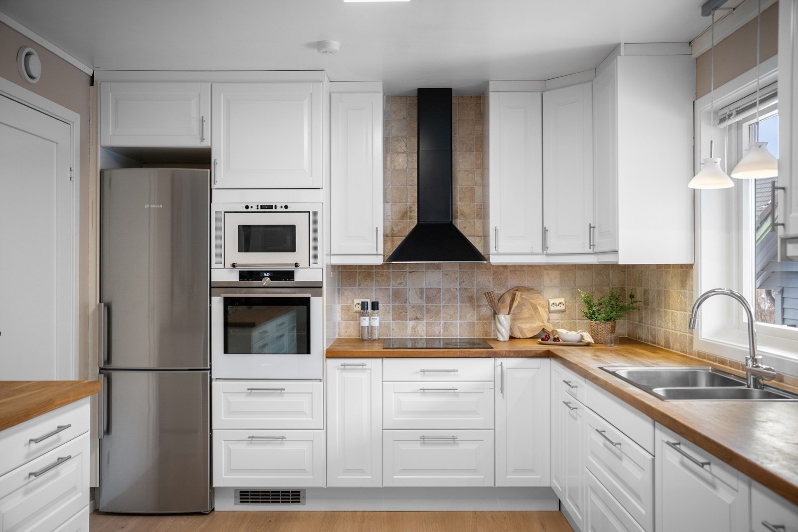 Delikate fliser over benk og nytt gulv. Hvitevarer i arbeidshøyde. Galleribilde