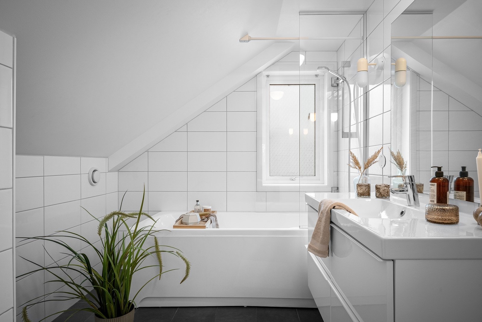 Familiebaderommet er både moderne og tidløst, med en praktisk løsning som kombinerer badekar og dusj i ett. Galleribilde