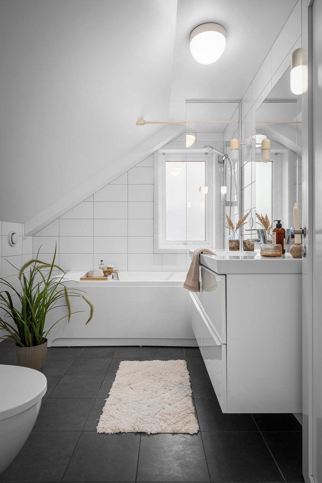 Familiebaderommet er både moderne og tidløst, med en praktisk løsning som kombinerer badekar og dusj i ett. Galleribilde