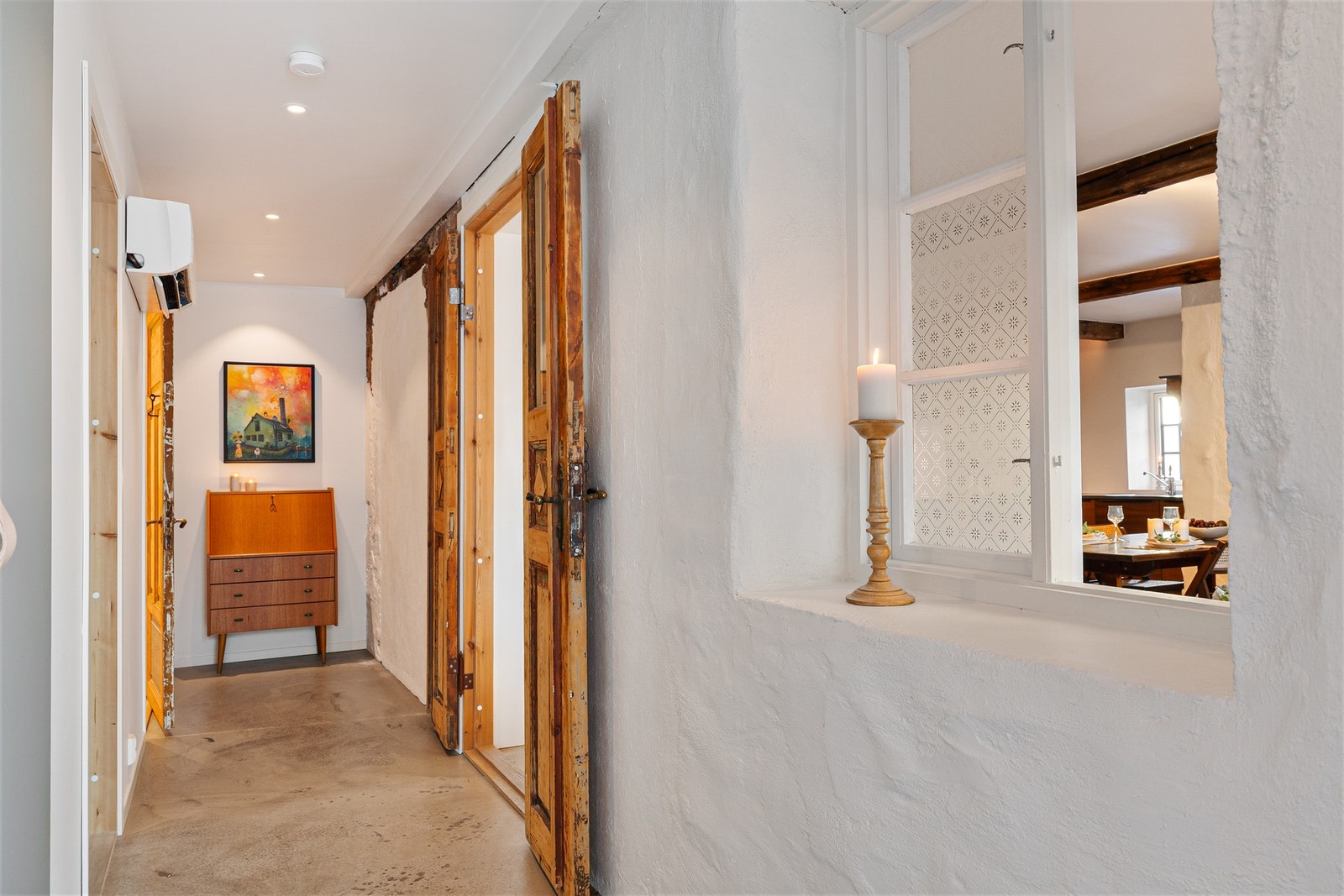 De gamle dørene er tatt vare på og gir huset et autentisk og arkitektonisk preg. Legg merke til det gamle vinduet mellom gang og stue. Galleribilde