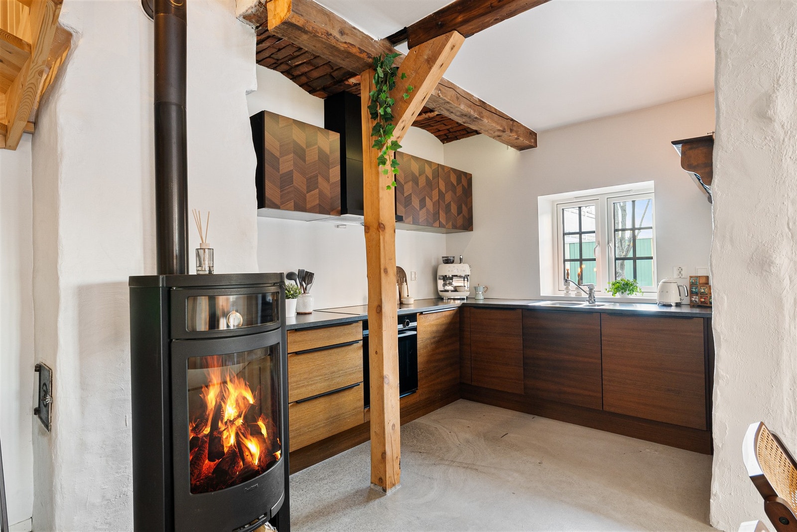 Kjøkkenet ligger delvis tilbaketrukket fra stuen. Legg merke til teglstein i taket fra Røykeriets tid Galleribilde