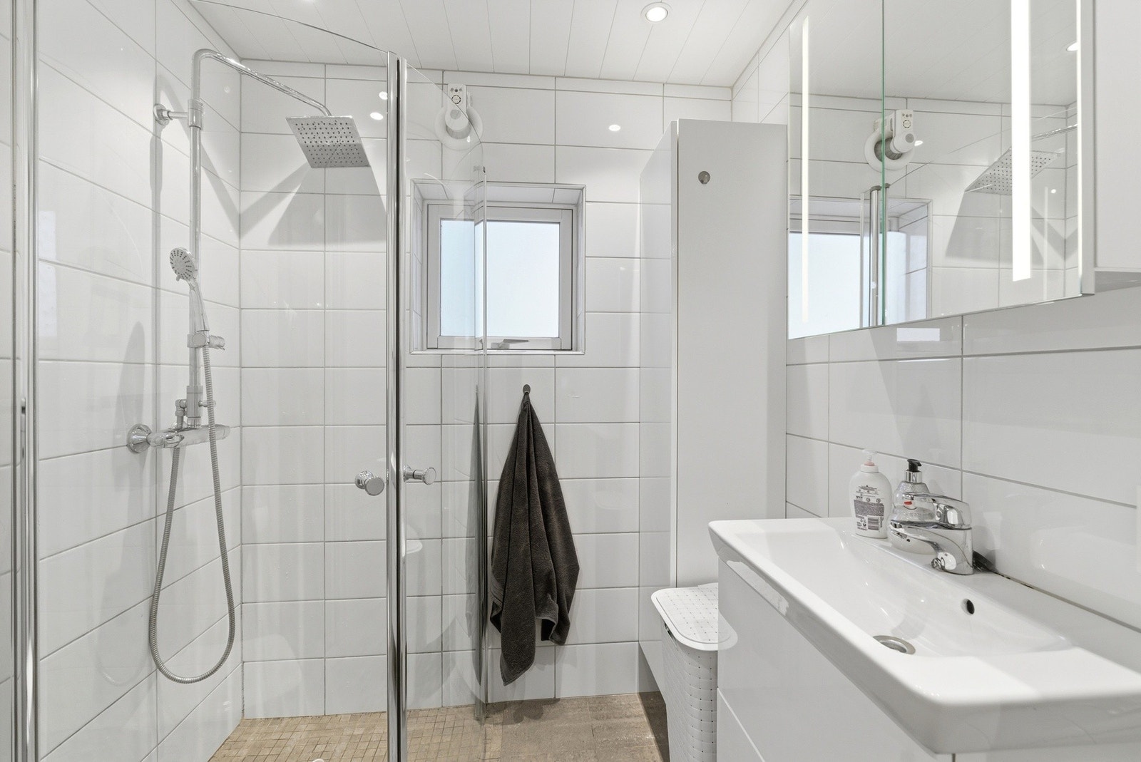 Deilikat og stilrent bad med varmekabler i gulvet. Badet har moderne innredning, speilskap, veggmontert toalett og dusjhjørne. Galleribilde