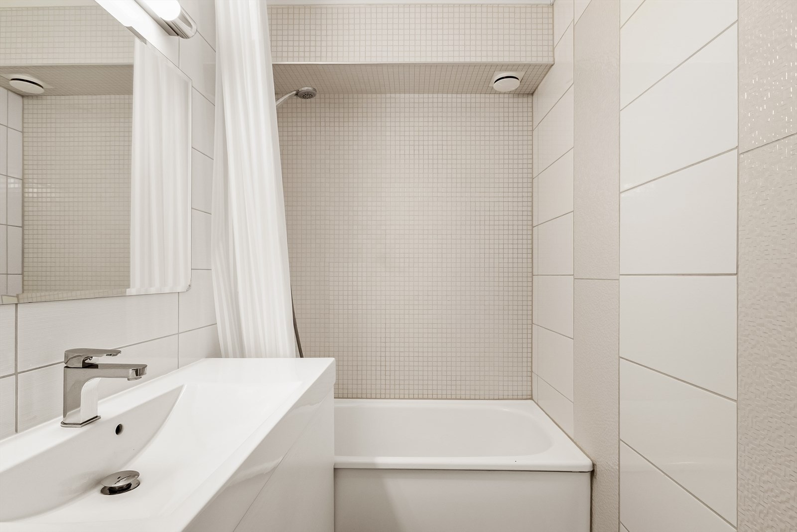 Pent flislagt bad med badekar og dusj - en praktisk og komfortabel løsning for både hverdag og velvære. Galleribilde