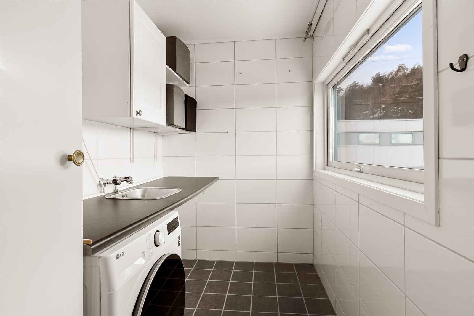 Praktisk separat vaskerom med benkeplass, skap og utslagsvask. Her er det også opplegg for vaskemaskin - en svært funksjonell løsning i hverdagen. Galleribilde