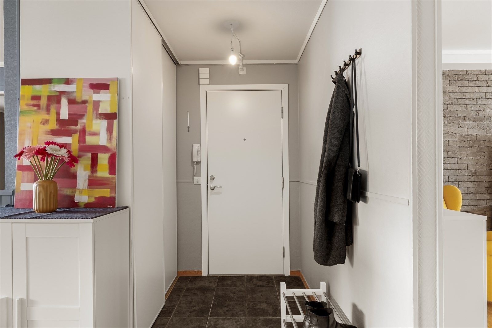 Første møte med leiligheten er en innbydende entré i åpen løsning mot stuen. Her finner du en praktisk skyvedørsgarderobe med god plass til yttertøy og oppbevaring. Galleribilde