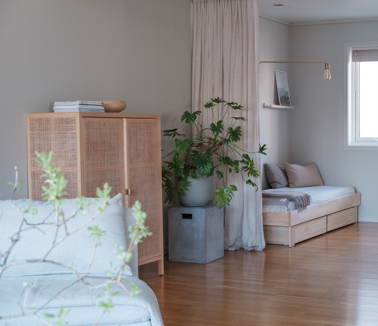 Stuen går i vinkel - noe som gjør det enkelt å dele rommet inn i soner. På tegninger er delen bak gardinen inntegnet som et ekstra soverom. Galleribilde