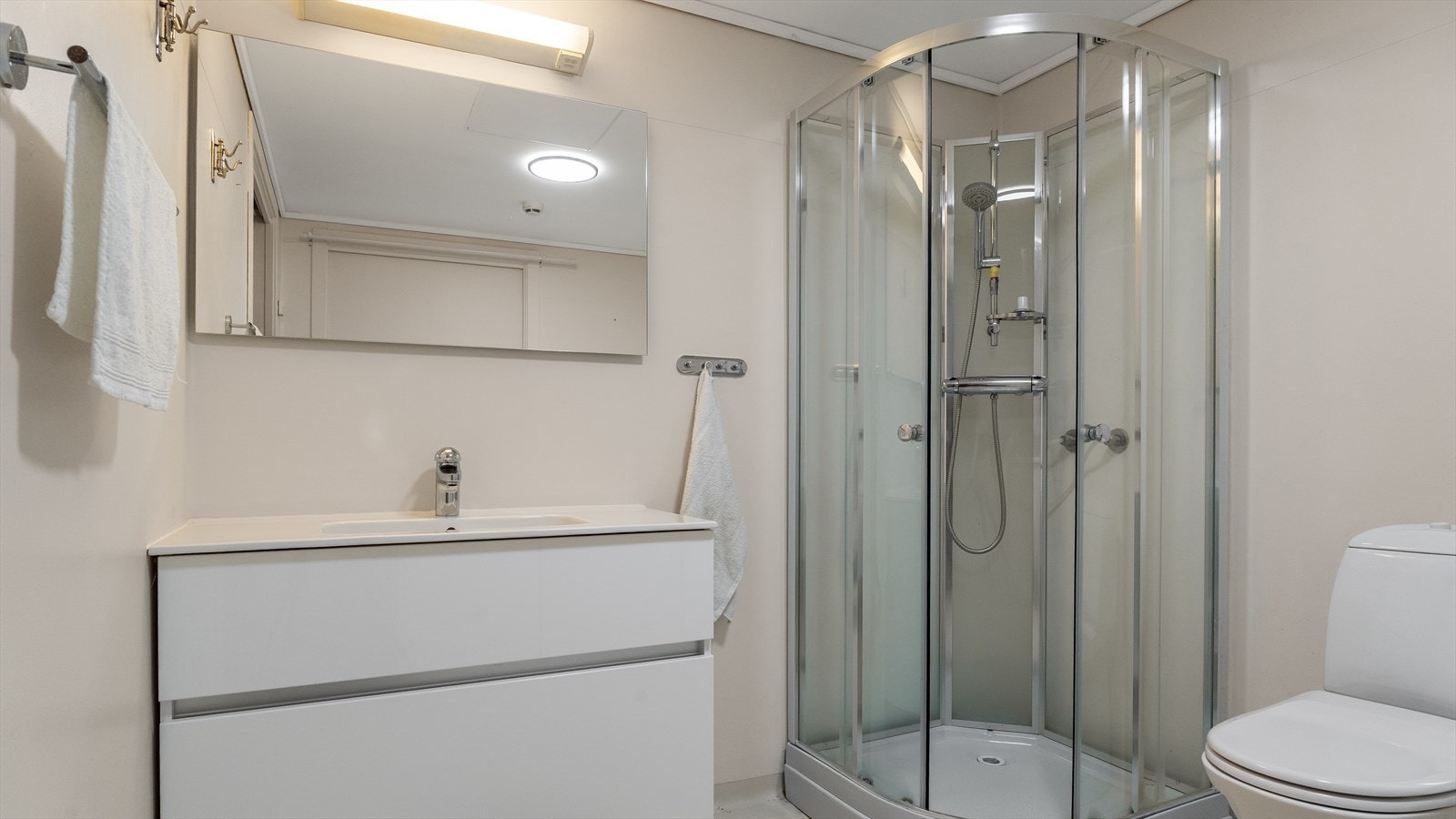 Praktisk og rommelig bad med servant, dusj, wc og opplegg for vaskemaskin. Galleribilde