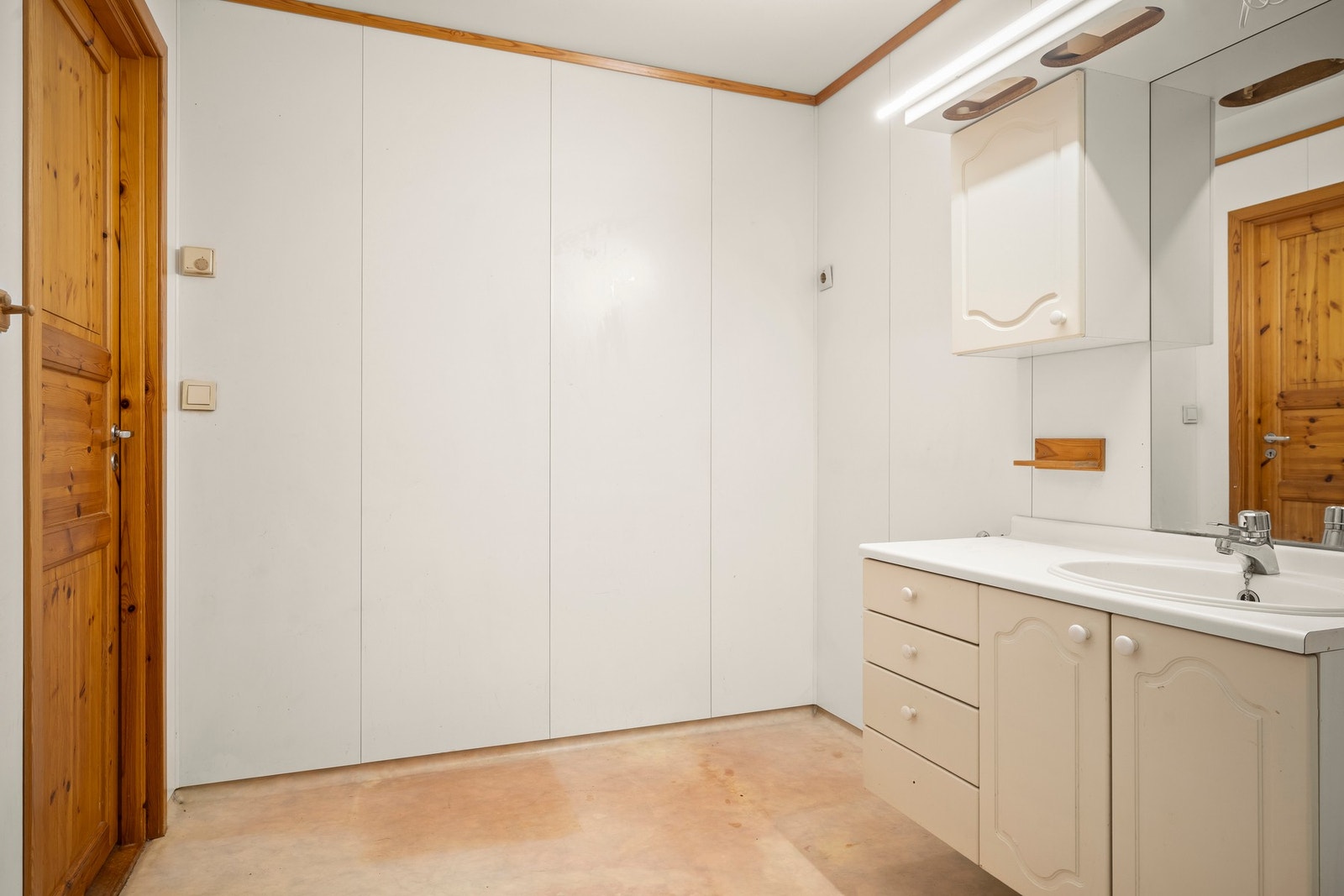 Vegger med baderomsplater, malt tak og gulv med vinylbelegg. Det er elektriske varmekabler i gulvet, plastsluk og vinylbelegg som tettesjikt. Galleribilde