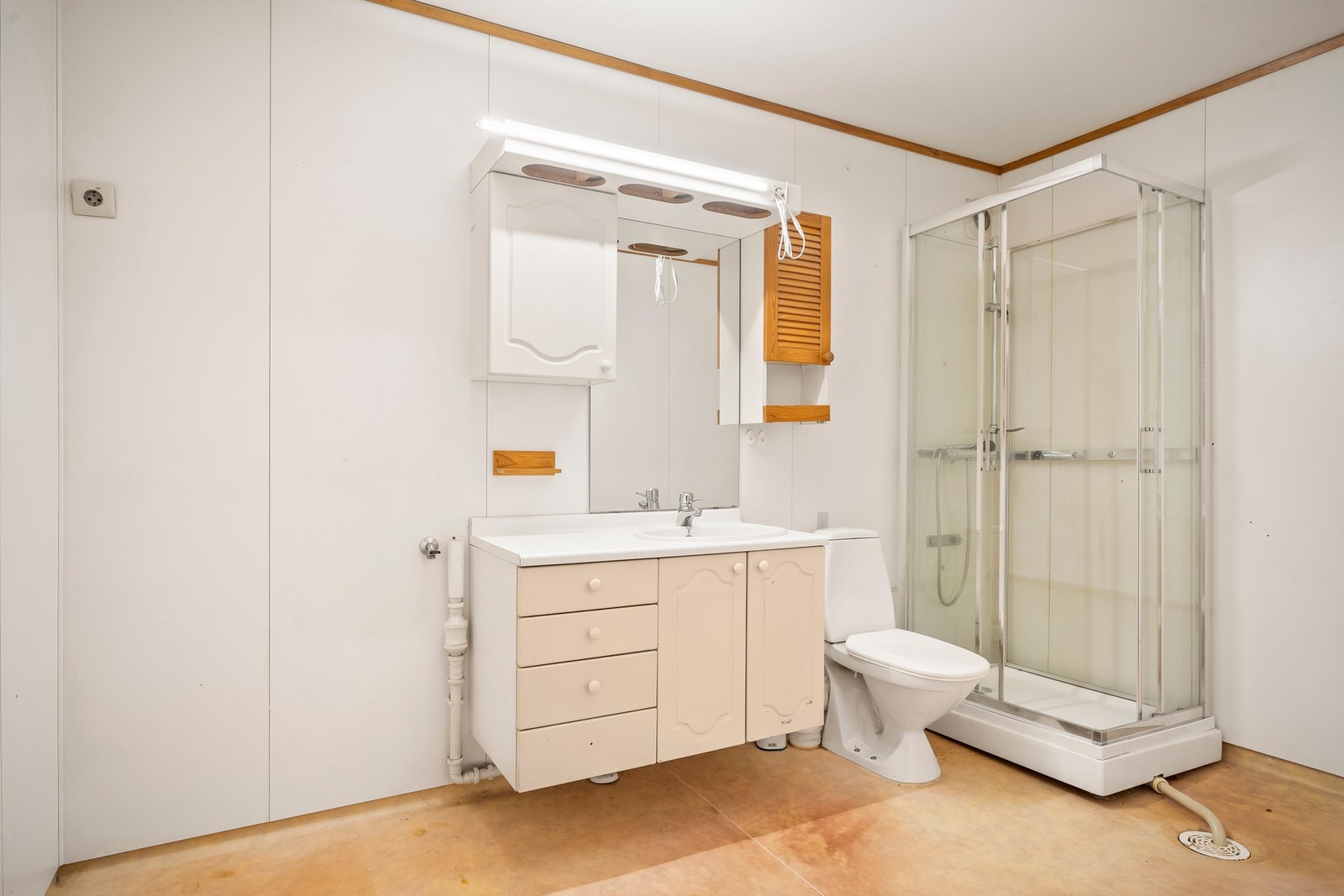 Baderommet er innredet med dusjkabinett, servant med underskap, speil, veggskap og toalett. Galleribilde