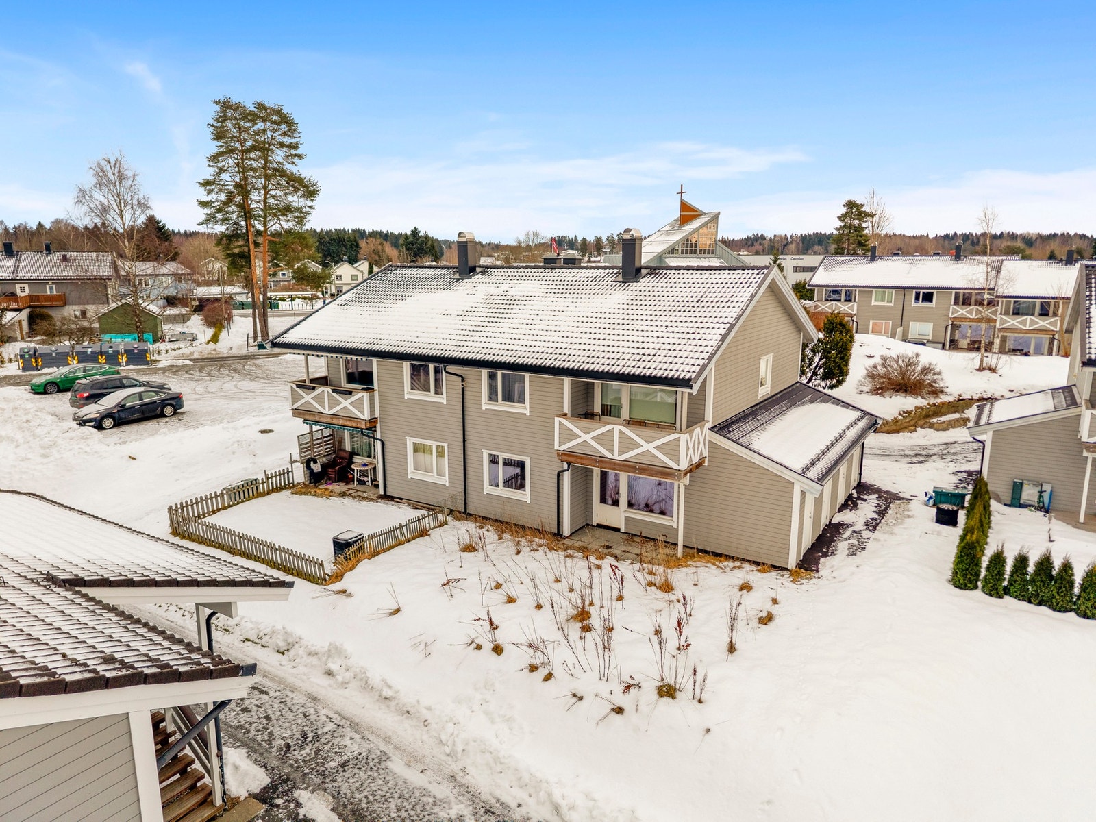 Leiligheten ligger i en firemannsbolig over to etasjer, bygget i treverk med beige fasade og hvite detaljer. Galleribilde