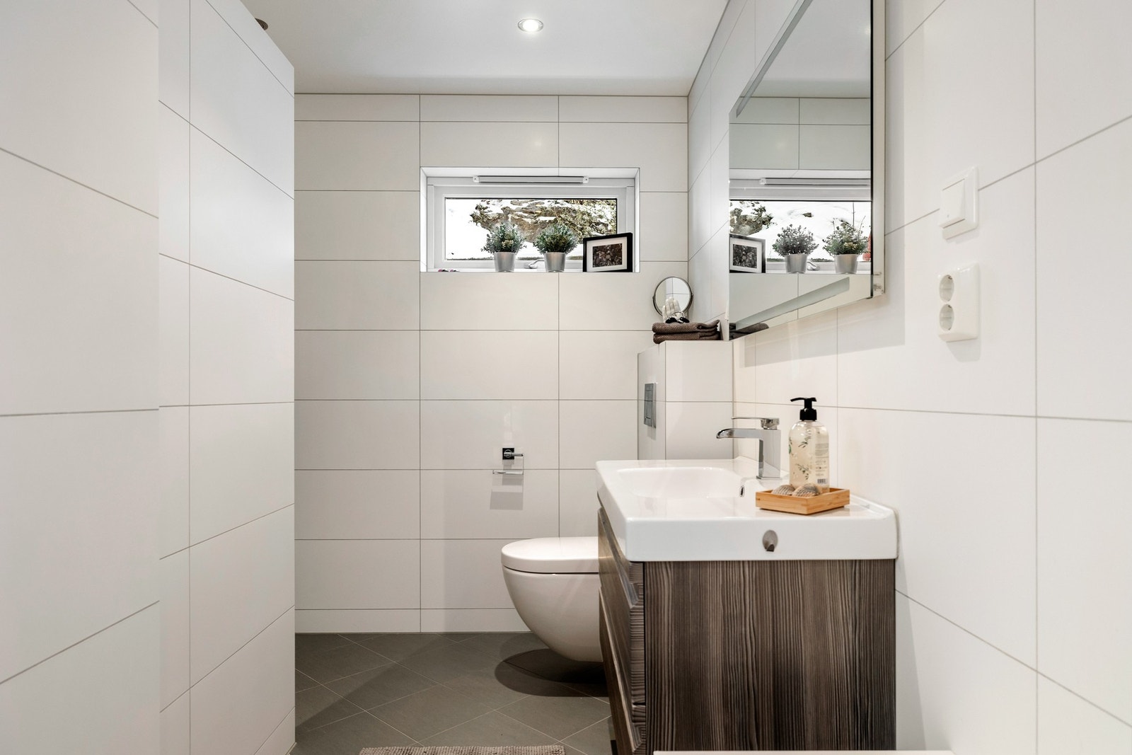 Innredningen består av innfelt servant med skuffeløsning, vegghengt toalett fra Geberit, Galleribilde