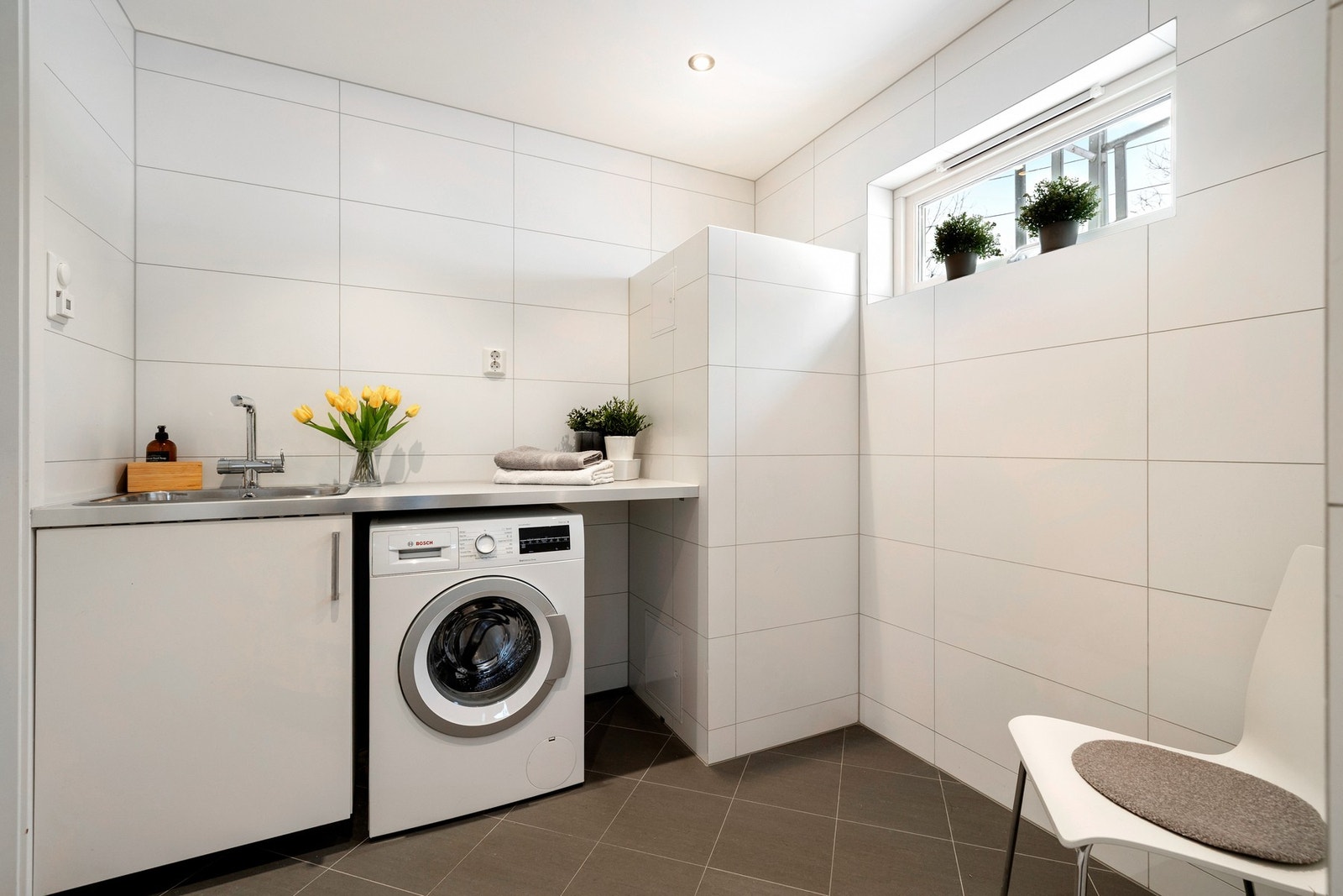 Badet er også tilrettelagt med vaskeromsfunksjon, med utslagsvask og opplegg for vaskemaskin, samt elektriske varmekabler i gulvet. Galleribilde