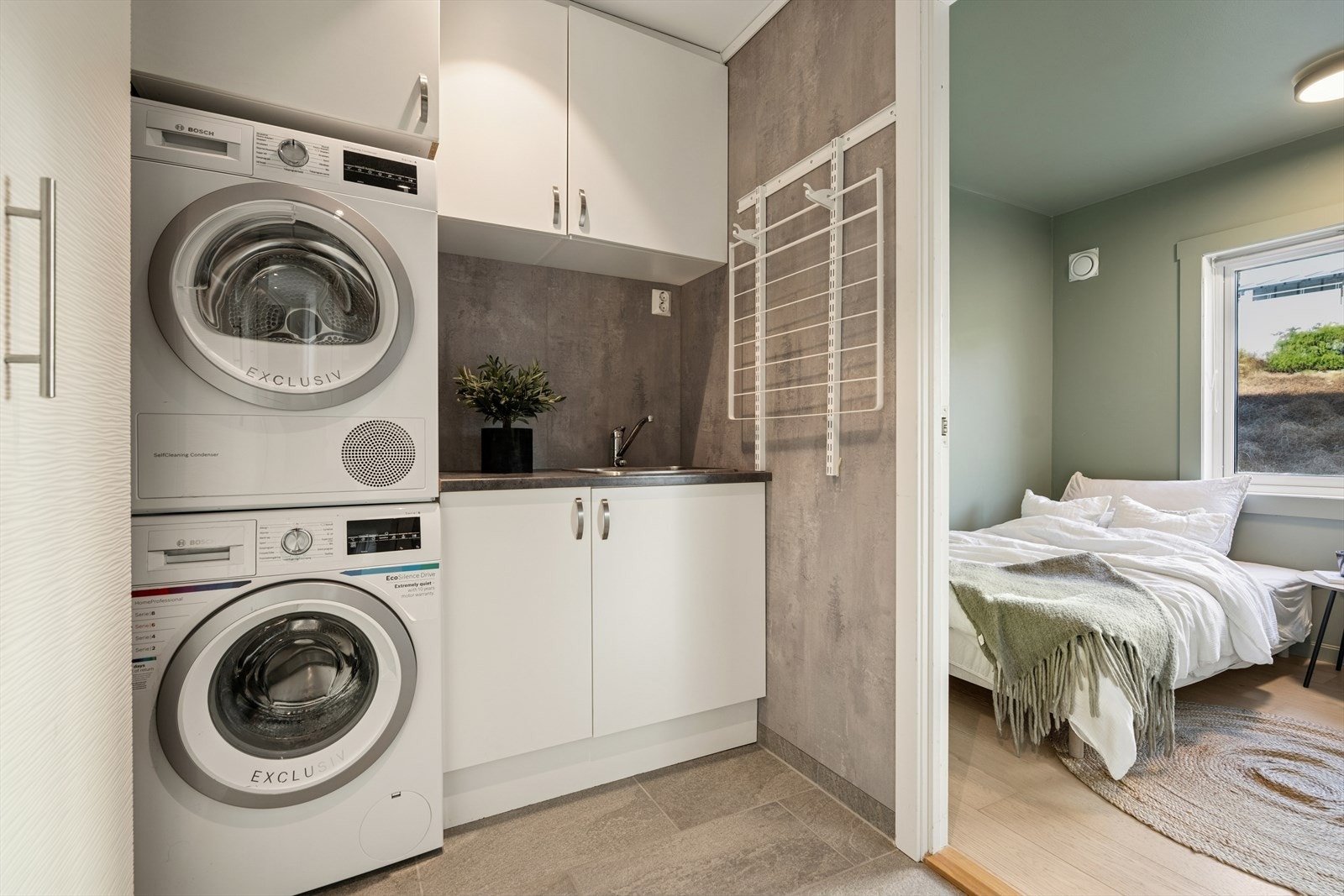 Rommet er utstyrt med både vask og god skapinnredning, noe som gir ryddige oppbevaringsmuligheter for vaskemidler, håndklær og annet utstyr. Her ligger alt til rette for en effektiv og organisert vaskesone med god arbeidsplass. Galleribilde