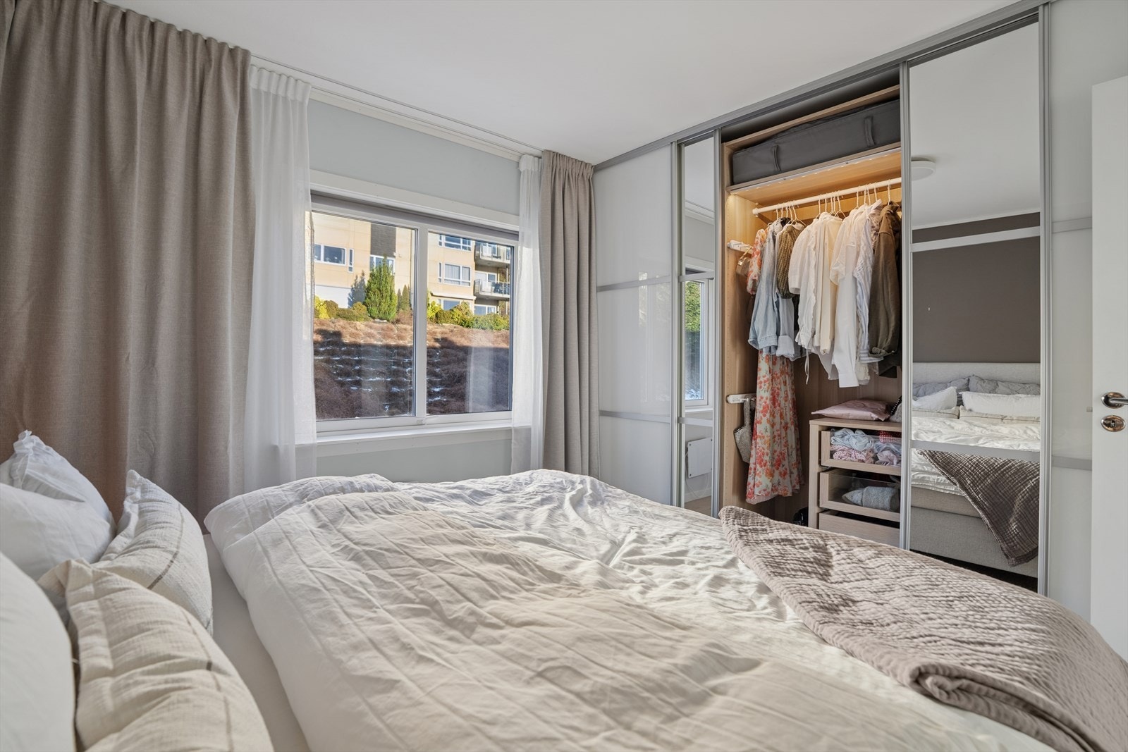 Rommet er utstyrt med en praktisk skyvedørsgarderobe som har en smart og funksjonell innredning, noe som gir effektiv oppbevaring og bidrar til et ryddig og organisert soveromsmiljø. Galleribilde