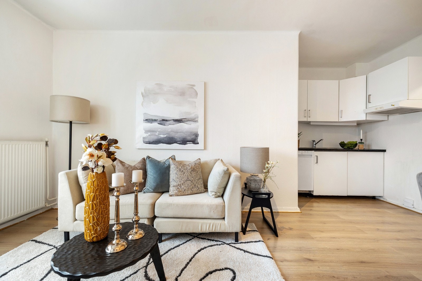 Leilighetens stue ligger i åpen løsning med kjøkkenet Galleribilde