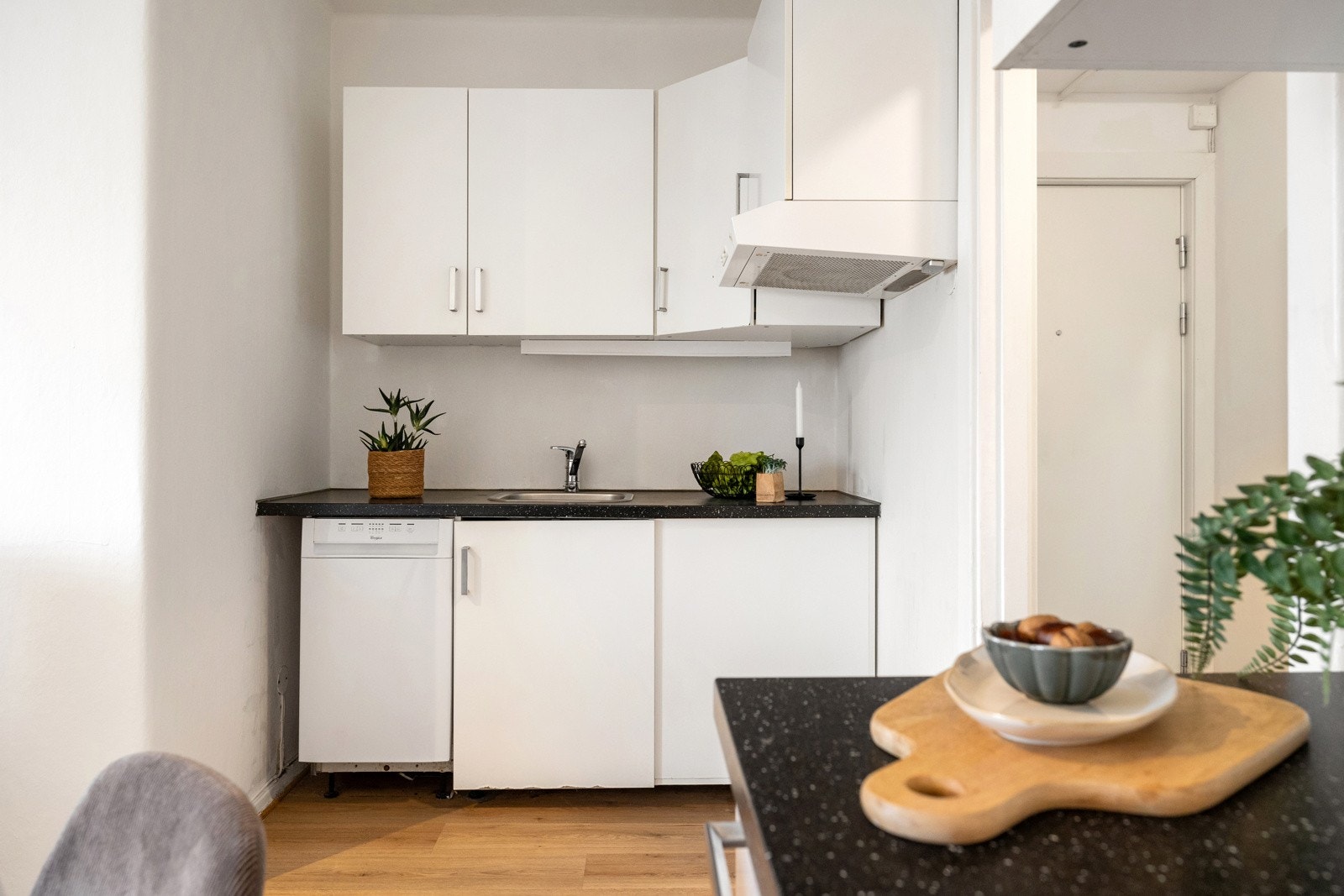 Kjøkkeninnredningen har glatte hvite fronter og laminat benkeplate - Kjøkkenet har moderniseringsbehov Galleribilde