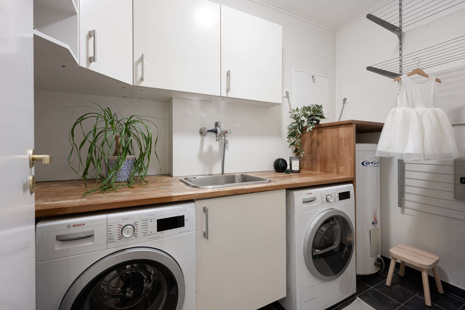 Praktisk vaskerom i kjelleren med gode oppbevaringsløsninger og opplegg for både vaskemaskin og tørketrommel. Galleribilde