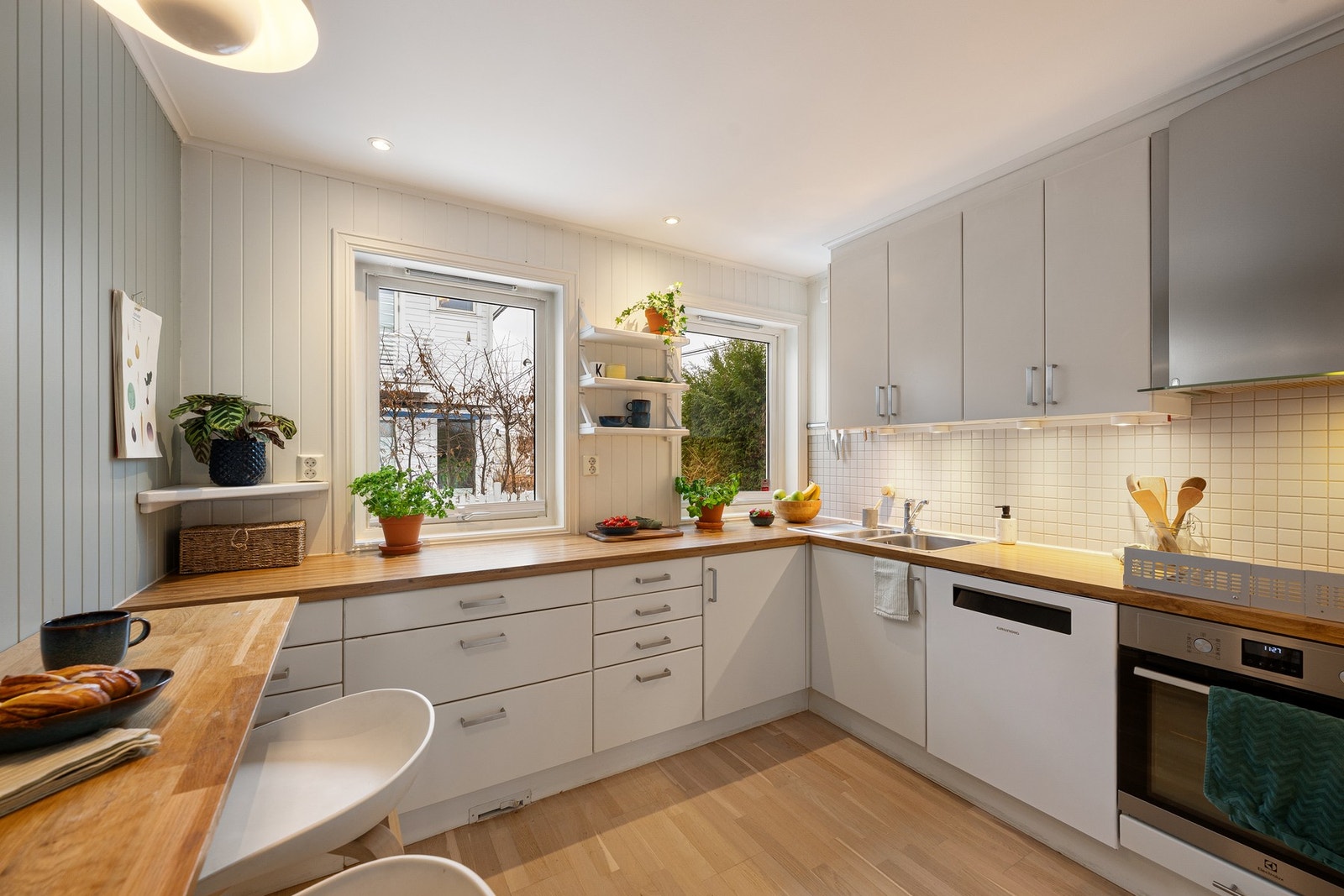 Innredning med glatte fronter og gode arbeidsflater, kombinert med fliser over benk for en robust og lettstelt løsning. Galleribilde