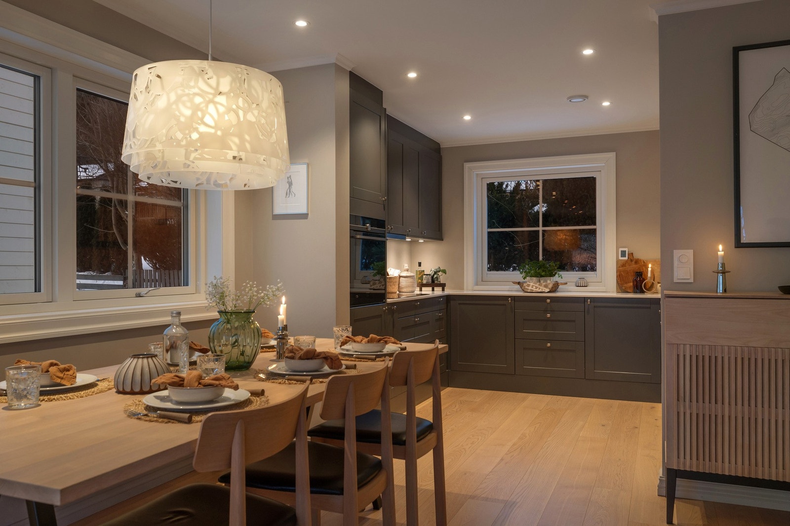 Kjøkken og spisestue byr på en varm og stemningsfull kveldsatmosfære, med peis som naturlig samlingspunkt. Galleribilde