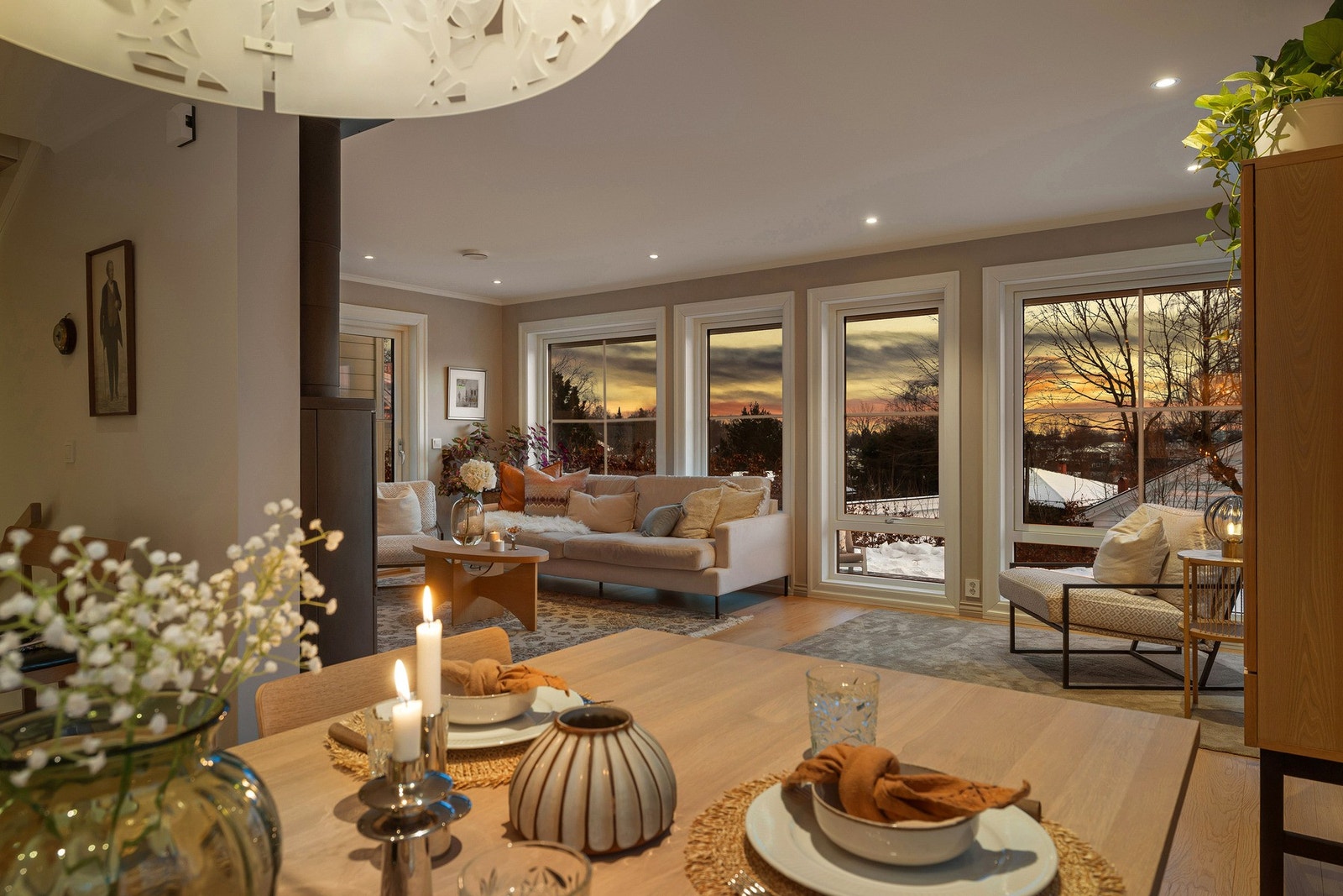 Stuen oppleves særlig hyggelig på kveldstid, med store vindusflater, levende lys og en rolig, innbydende stemning. Galleribilde