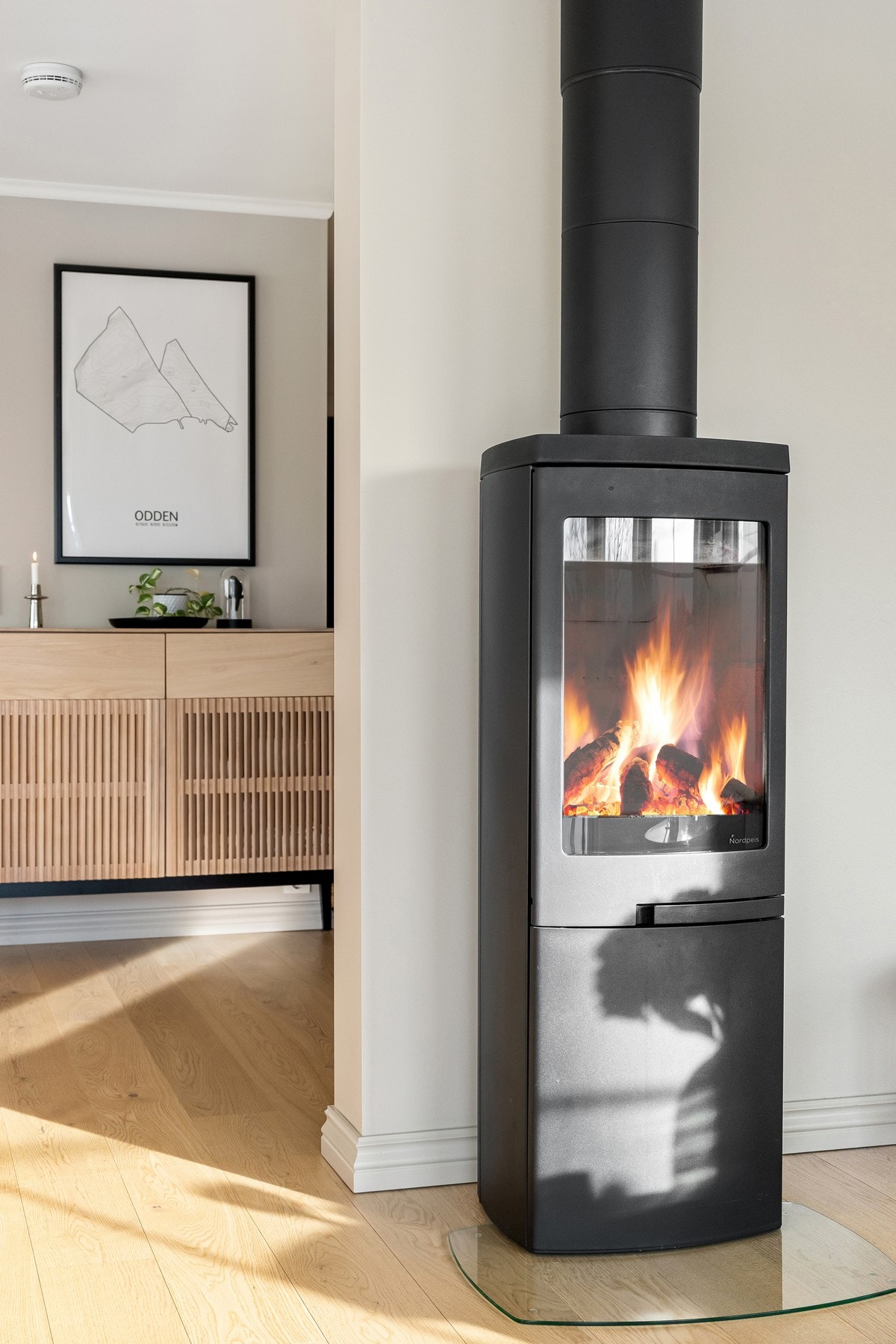 Som et stemningsfullt og funksjonelt midtpunkt har stuen en flott peisovn med glassfelt fra Nordpeis. Galleribilde