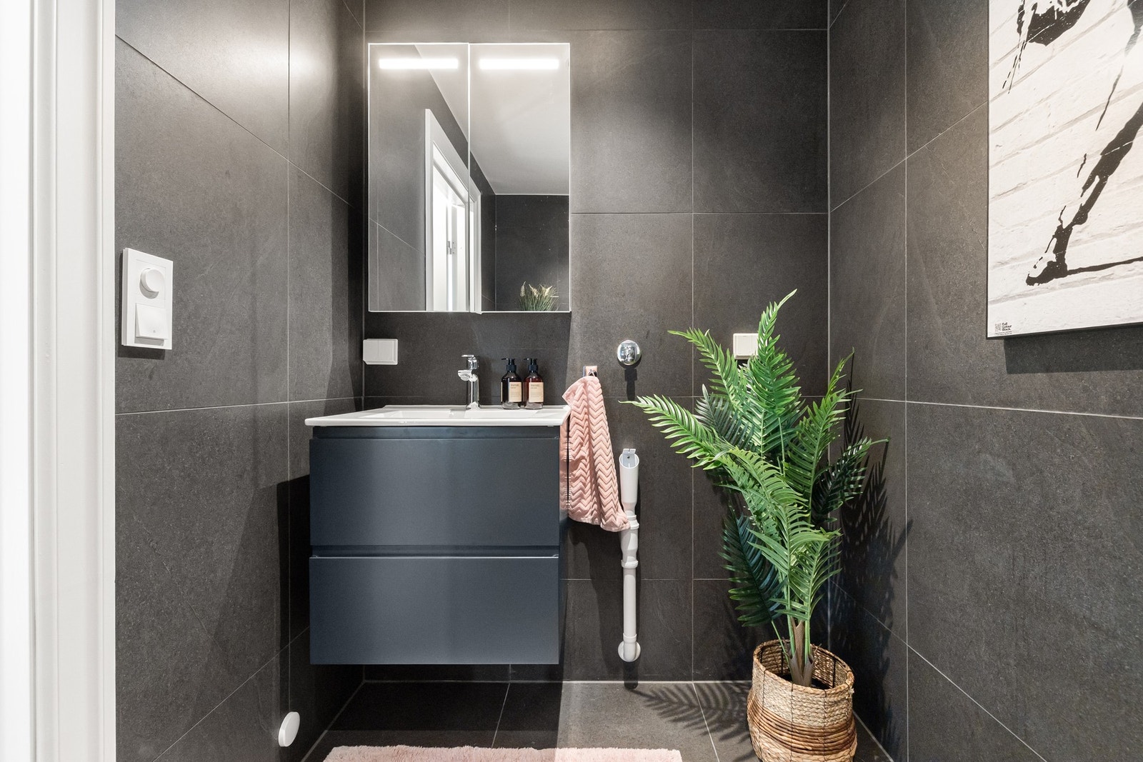 Badet er praktisk innredet med dusjnisje, vegghengt WC, servantskap med speilskap og opplegg for vaskemaskin og tørketrommel. Galleribilde