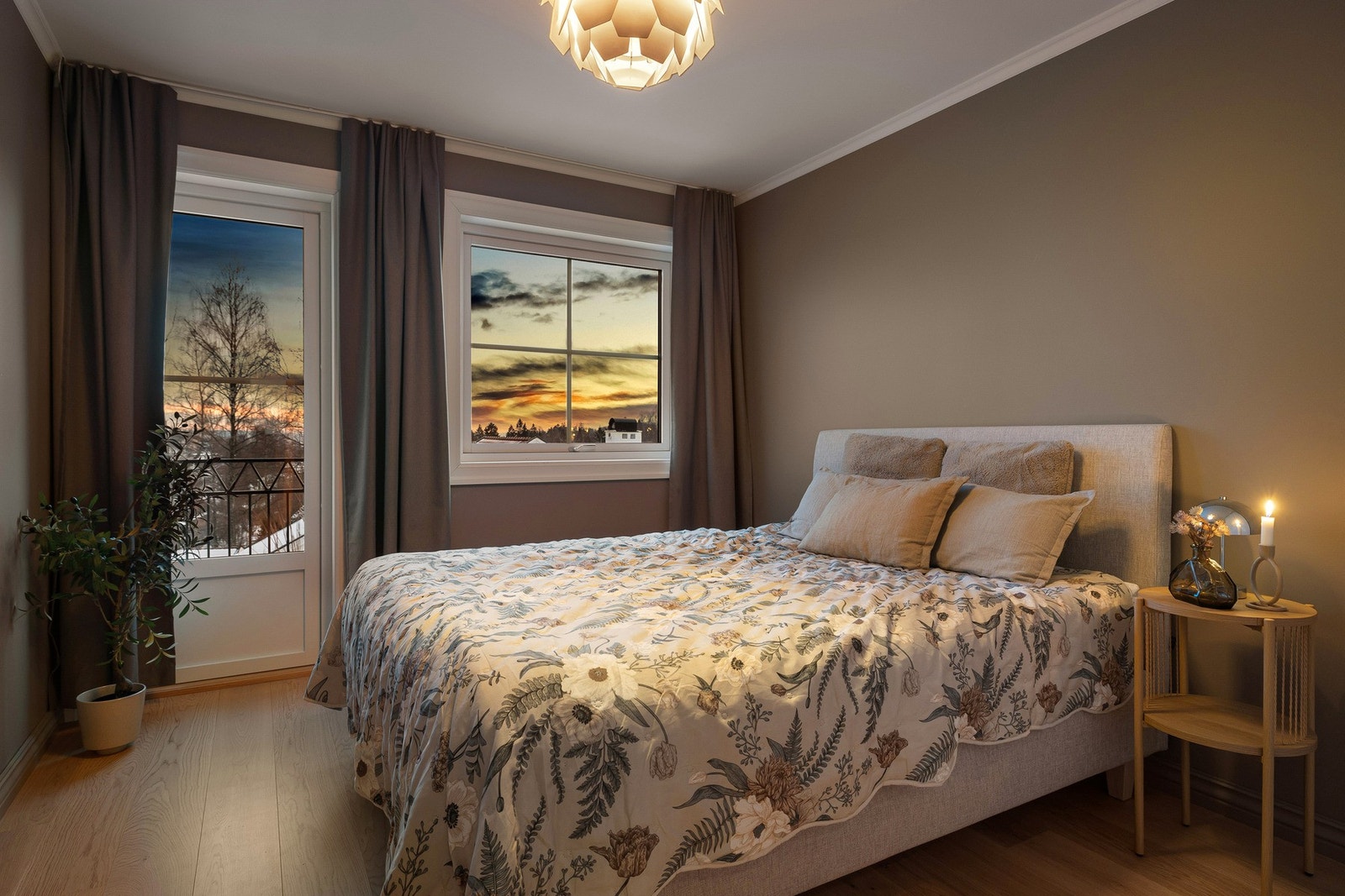 Soverommet får en lun og behagelig atmosfære på kveldstid, med mykt lys og utsyn mot kveldshimmelen. Galleribilde