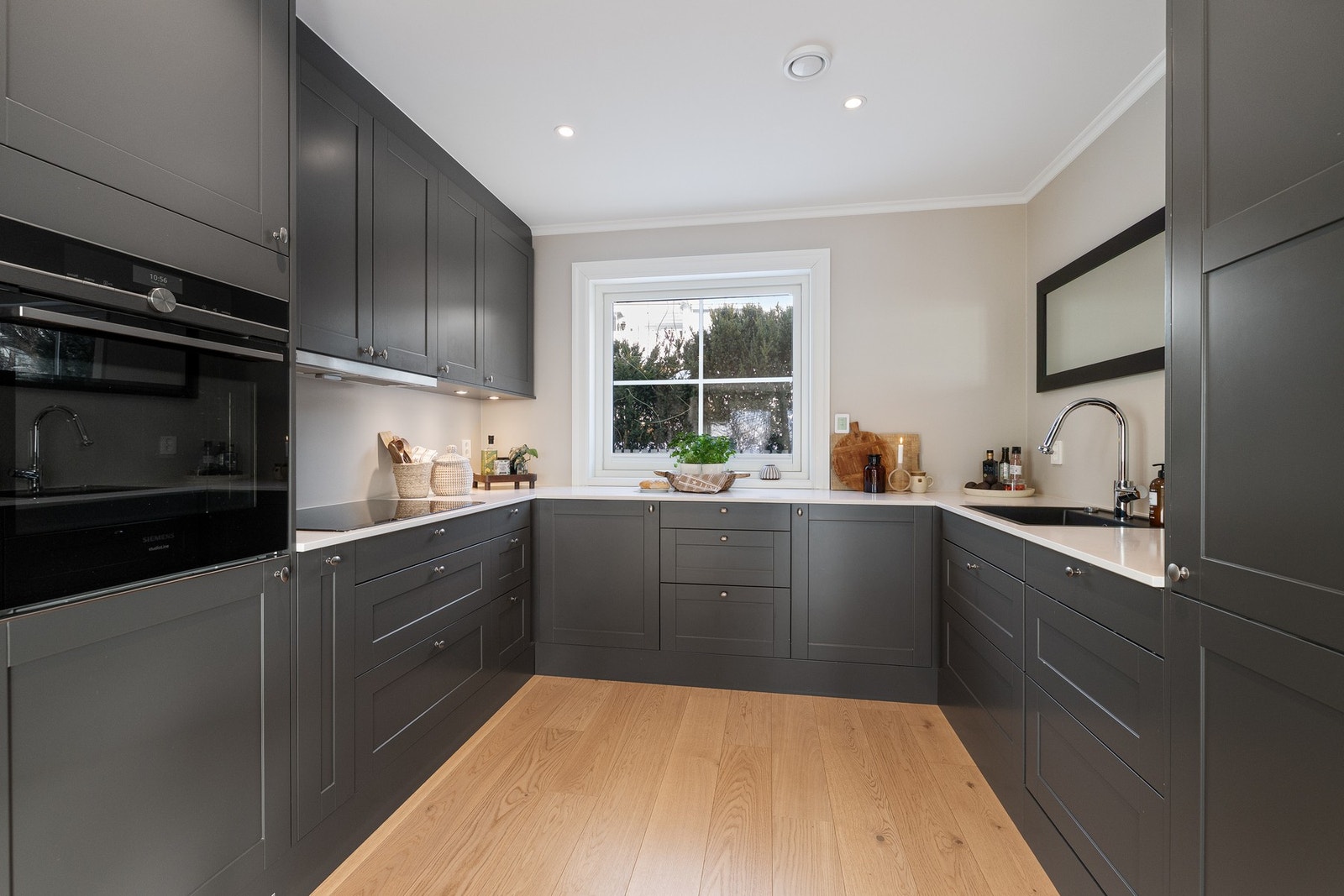 Kjøkkenets innredning er levert fra Sigdal, med profilerte fronter og benkeplate i kompositt. Galleribilde