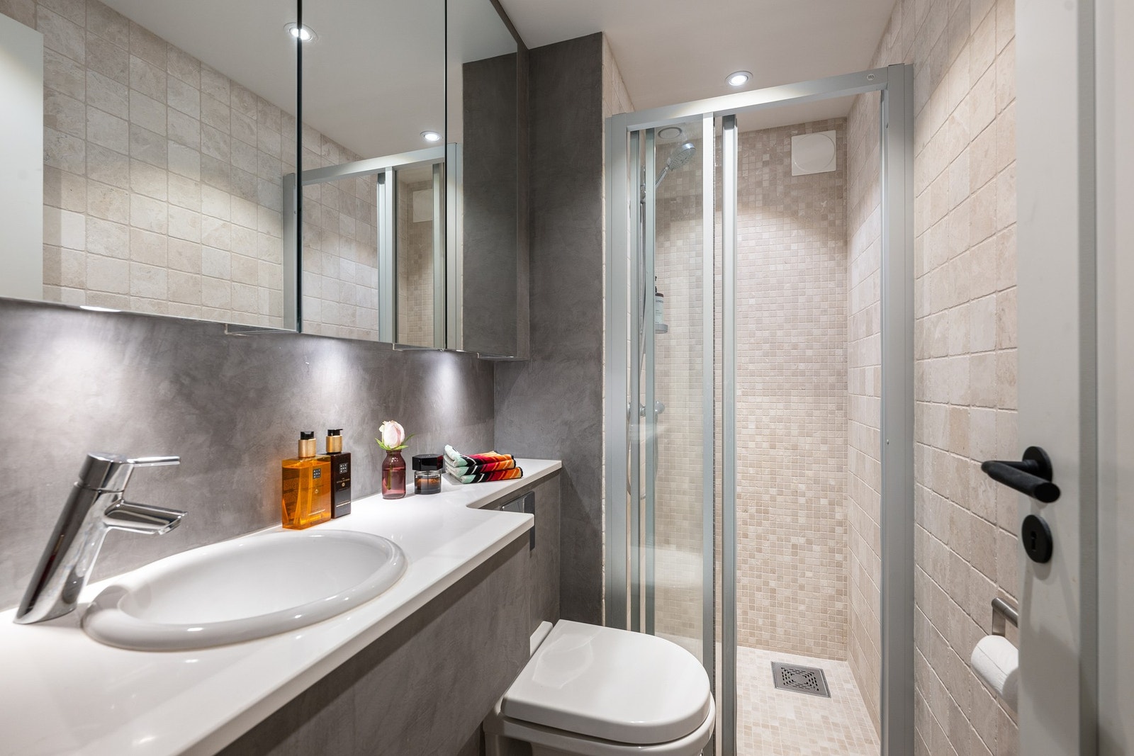 Bad nr. 2 fra 2011 med moderne mikrosement på gulv og delvis på vegger, kombinert med fliser og pene mosaikkfliser i dusjsonen. Galleribilde