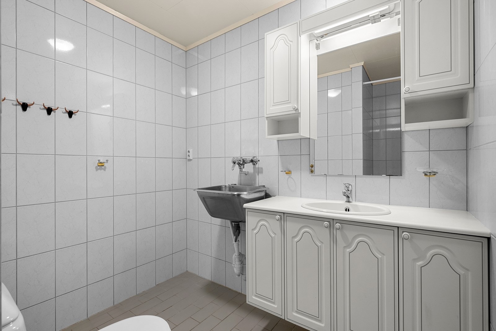 Leiligheten har et romslig bad på 5,2 m², utstyrt med utslagsvask, dusjhjørne, toalett og baderomsinnredning. Galleribilde