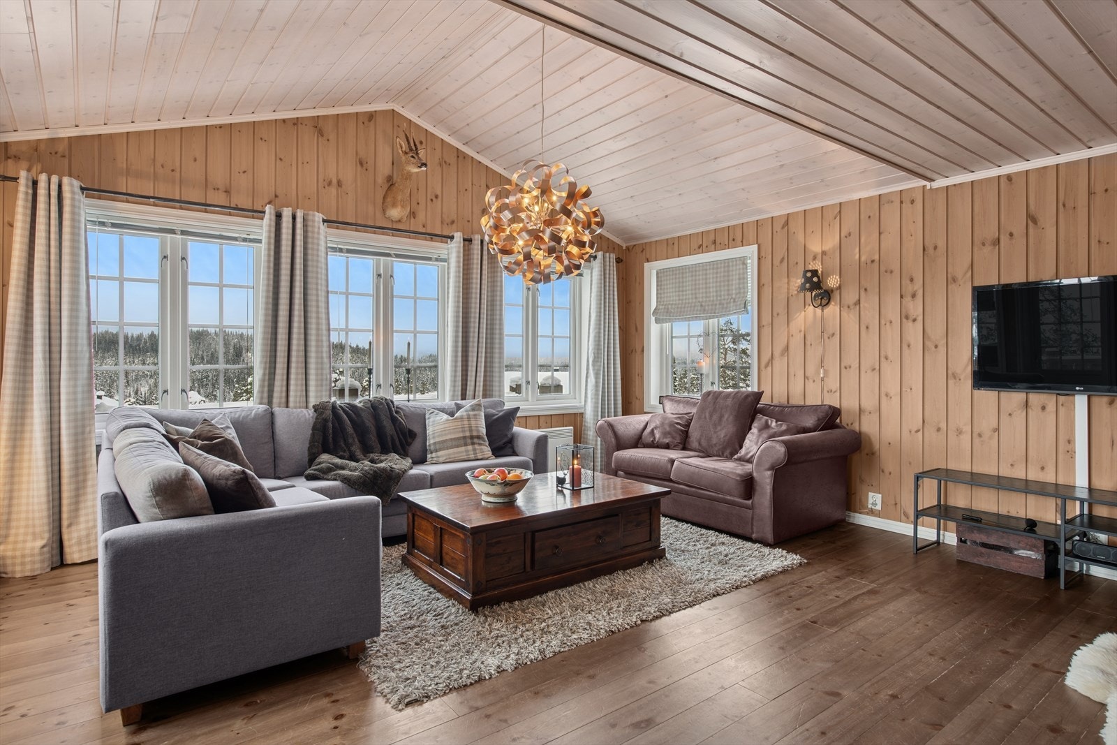 Stuen med åpen himling og store vinduer gir lys fra tre himmelretninger, utsikt uten innsyn - et rom som løfter både stemning og utsikt til nye høyder. Galleribilde