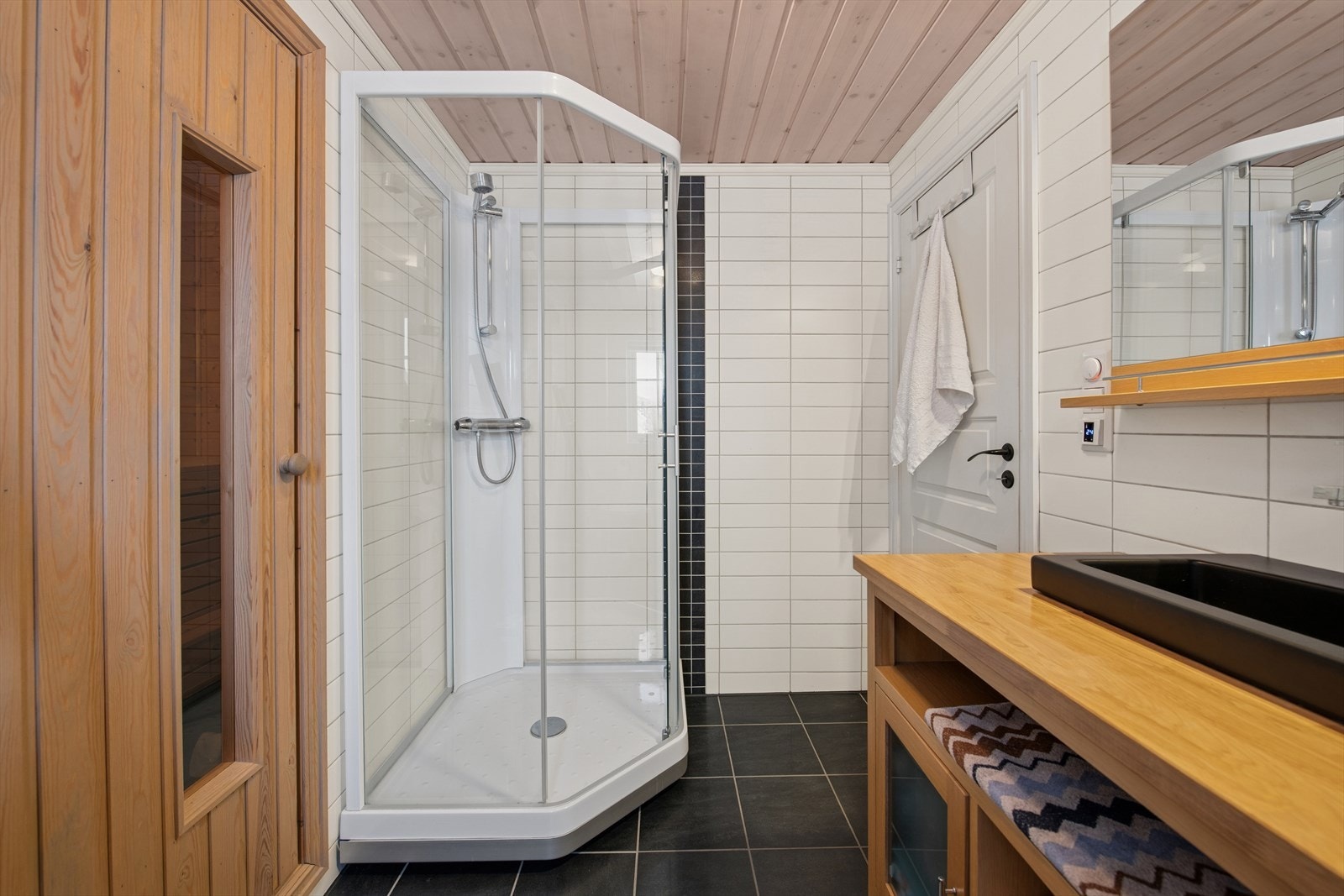 Moderne baderom med heldekkende servant, opplegg til vaskemaskin og adkomst til badstue. Galleribilde