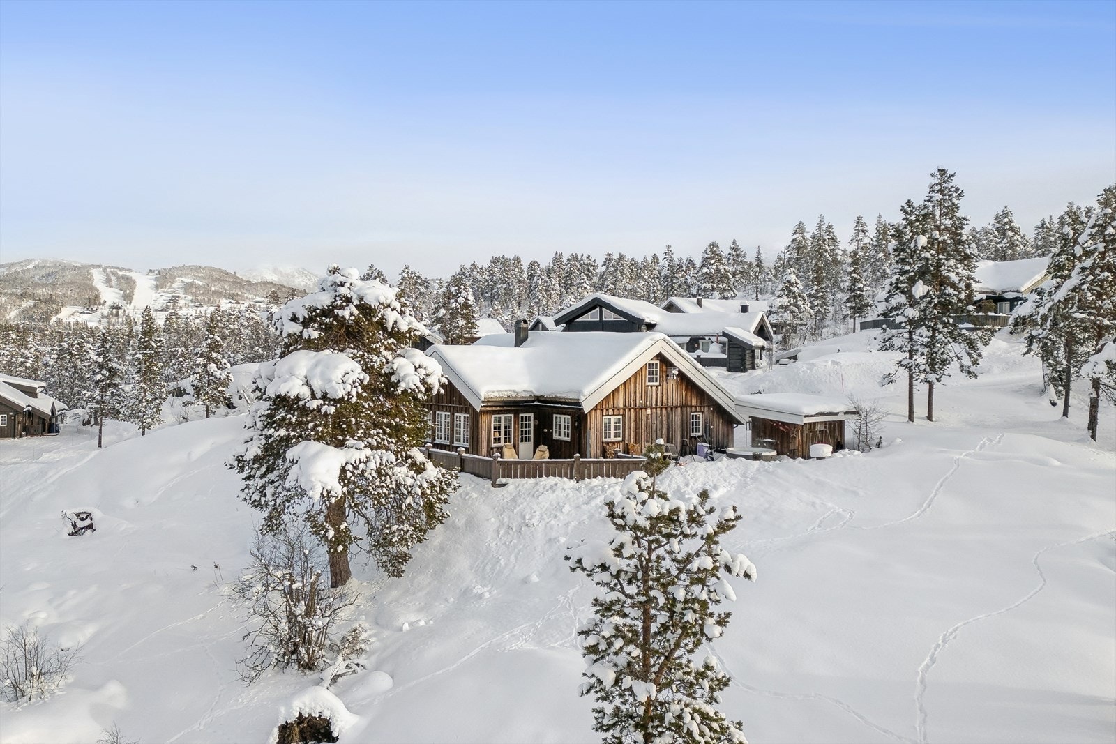 Klassisk lodge-stil med villmarkspanel, torvtak og tidløse sprossevinduer - en hytte som harmonerer med naturen og inviterer til ro og tidløs eleganse. Galleribilde