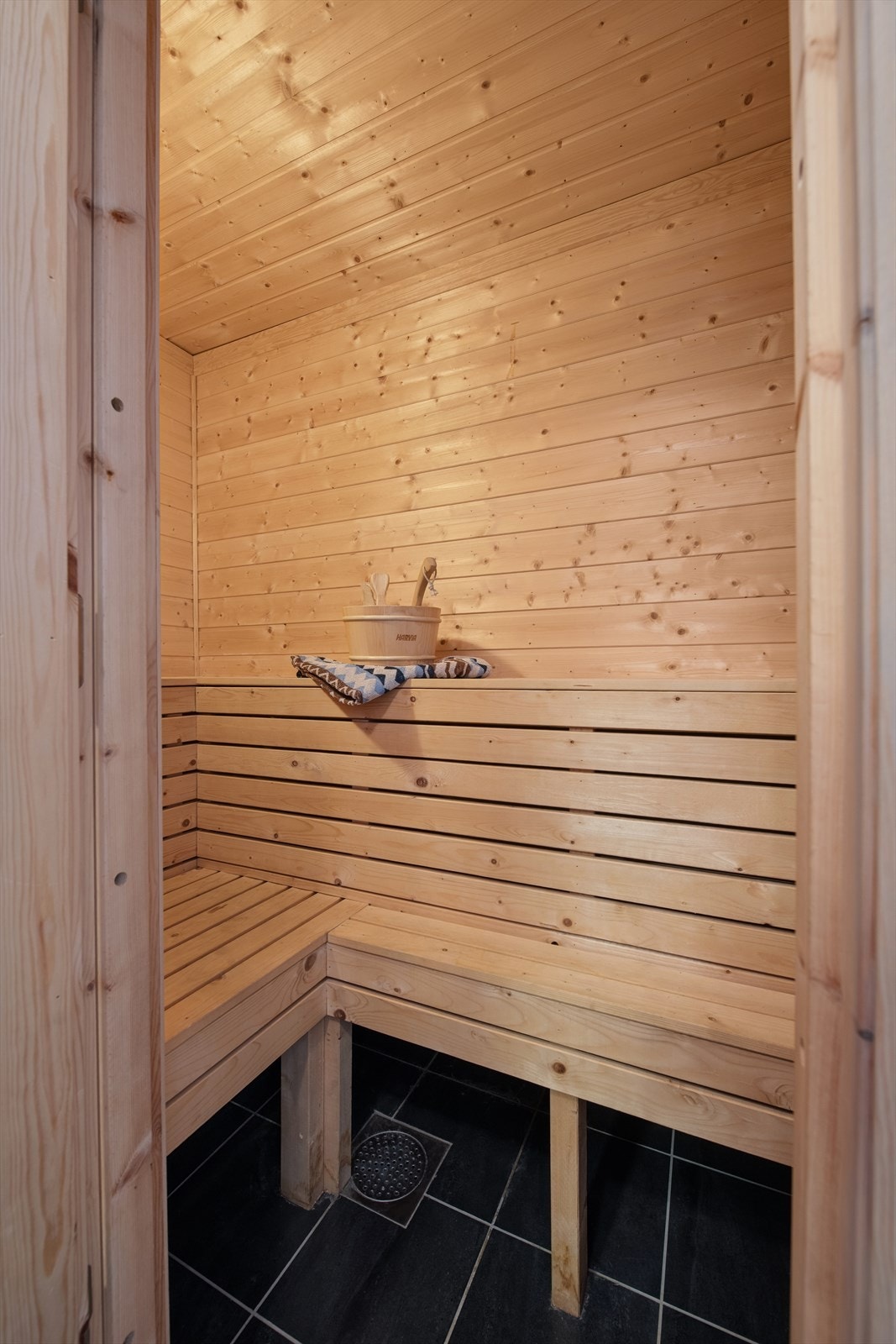 Badstuen med varme panelte flater og komfortable sittebenker ligger praktisk ved dusjsonen - perfekt for avslapning etter lange dager ute Galleribilde