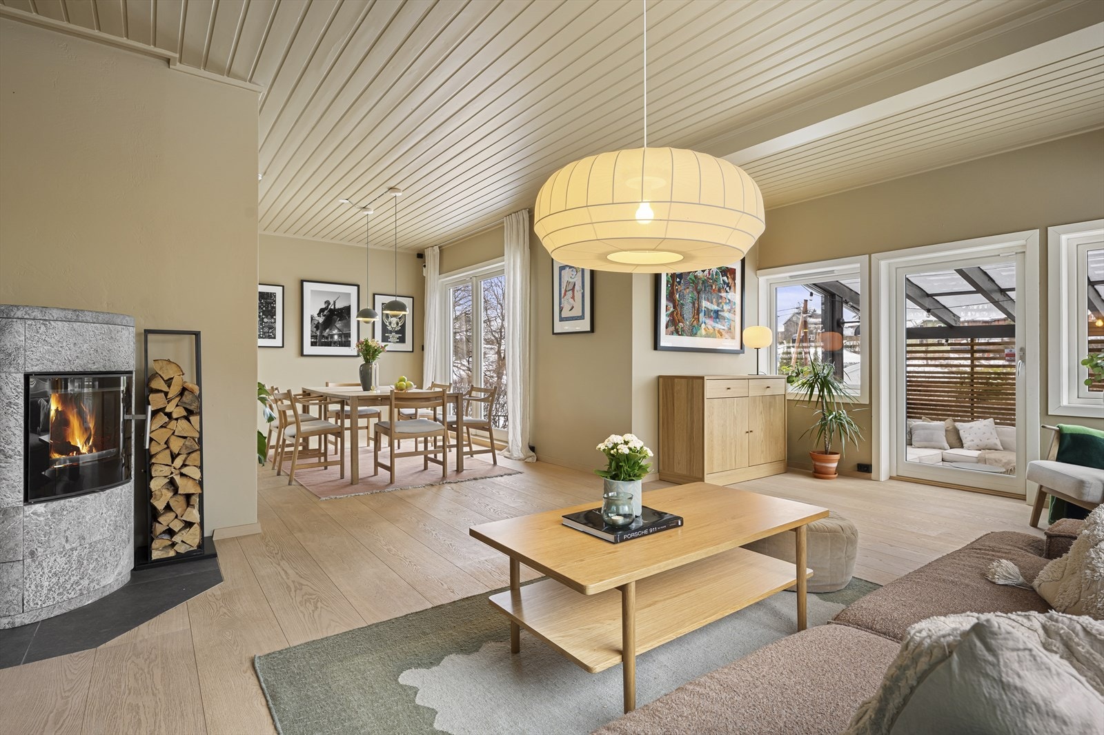 Stor stue i første etasje med vinduer og verandadør ut mot overbygget markterrasse. Galleribilde