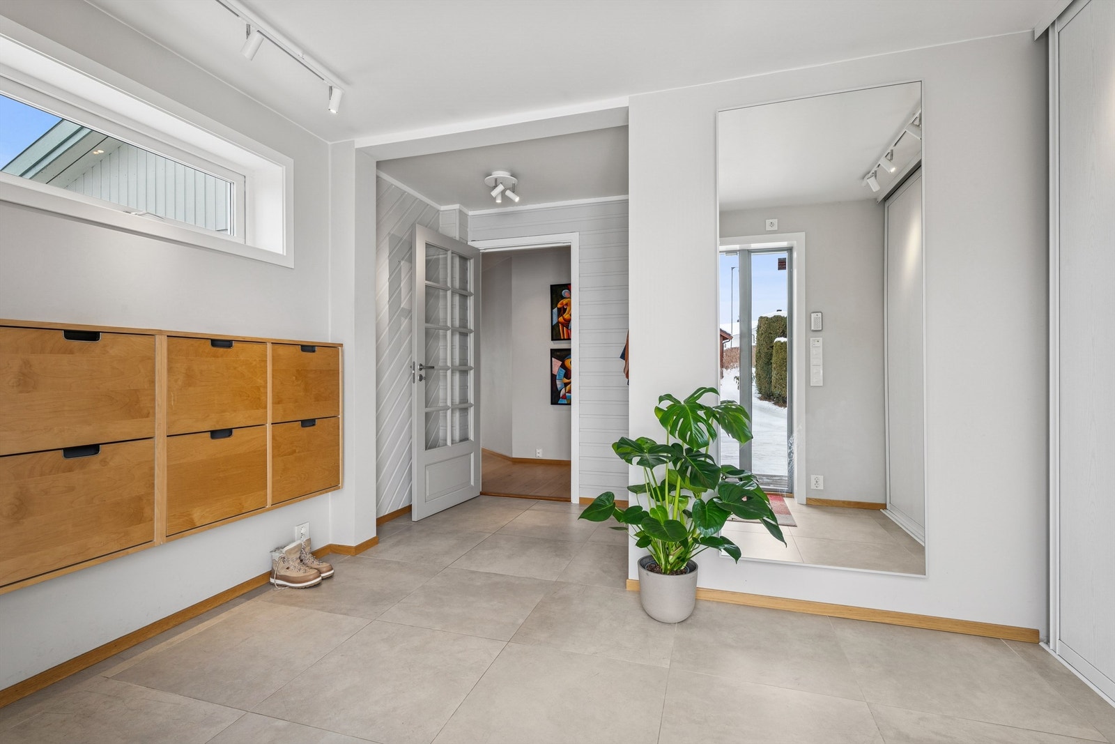 Flott og romslig entré med flislagt gulv og garderobeløsning. Galleribilde