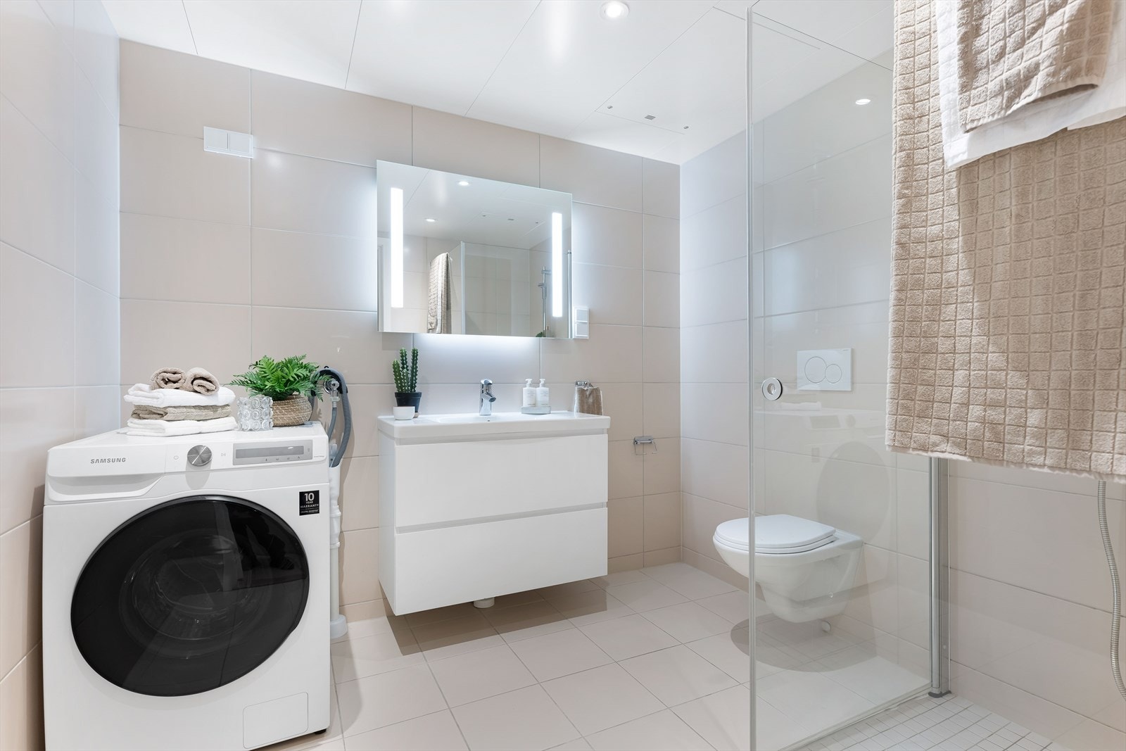 Pent og funksjonelt fliselagt bad som inneholder både stil og komfort. Galleribilde