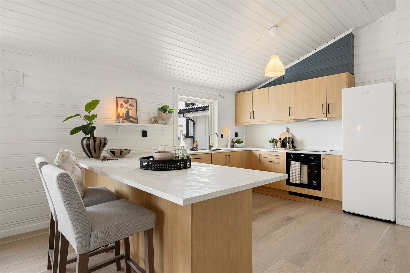 Pent og romslig kjøkken med rikelig skapplass og praktisk øy. Galleribilde