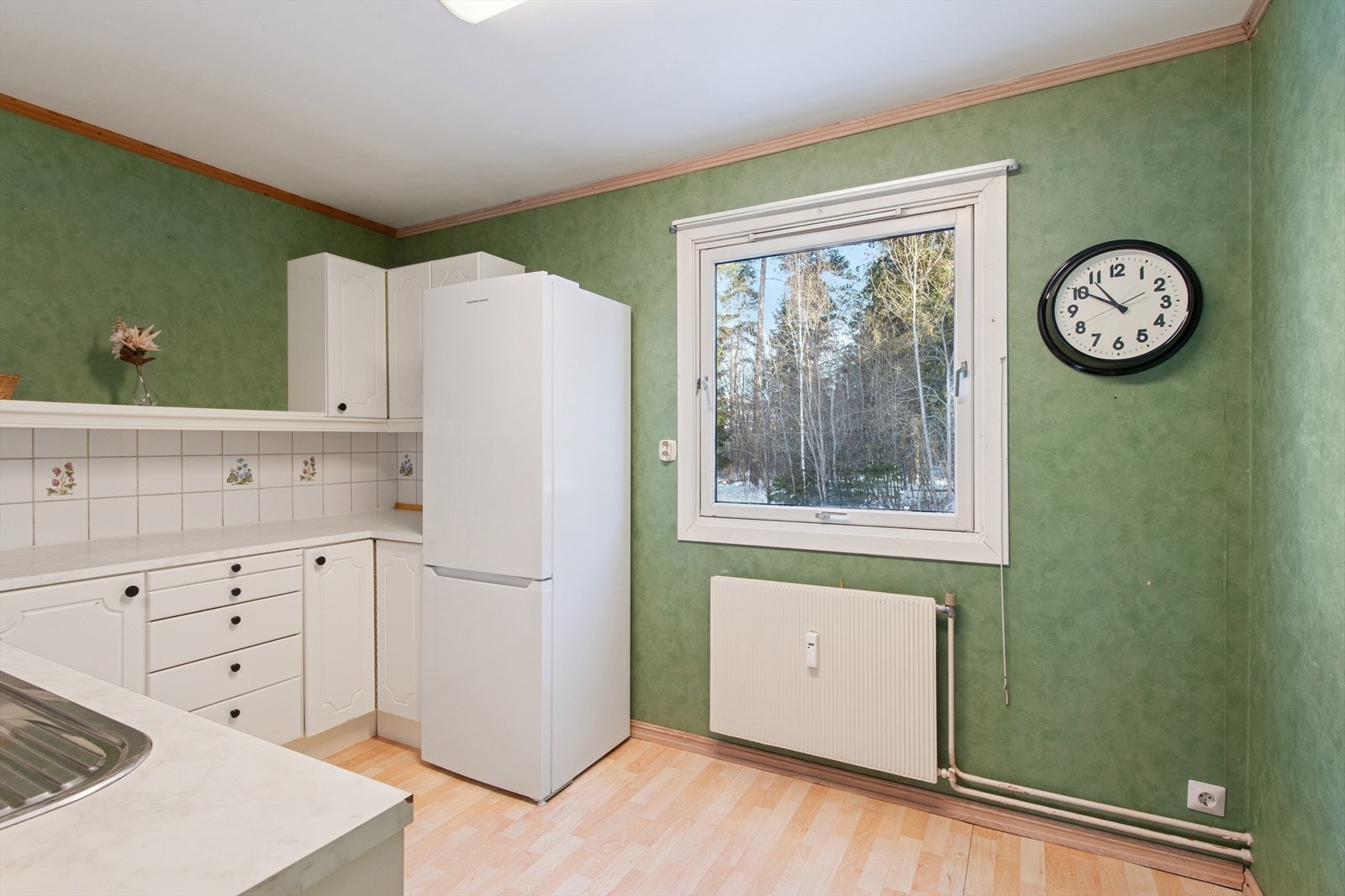 Over- og underskap med profilerte fronter i hvitlakkert utførelse. Fliser i benkerygg. Galleribilde