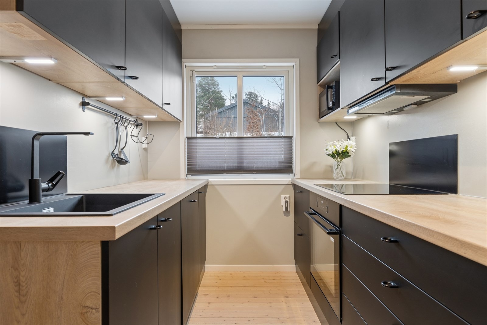 Pent kjøkken fra 2020 med sorte slette fronter Galleribilde