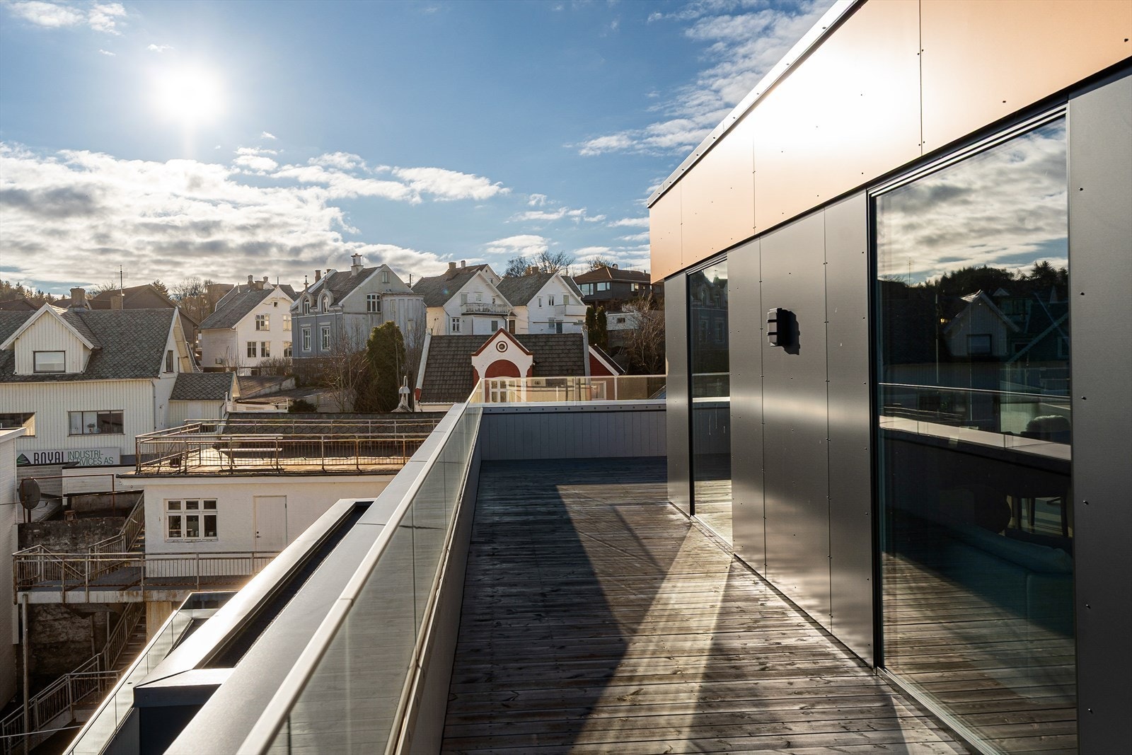 Takterrassen er tekket med asfaltpapp og belagt med terrassebord - rekkverket er utført i kombinasjon av tre og glass Galleribilde
