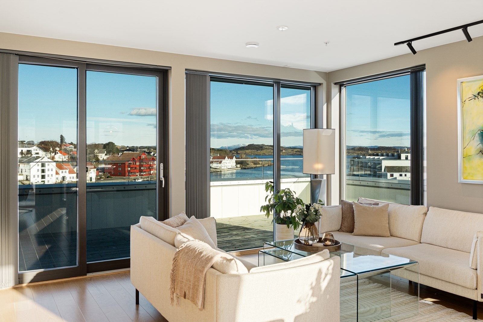 Fra rommet er det to store skyvedører med direkte utgang til det flotte terrasseområdet som strekker seg rundt tre sider av leiligheten Galleribilde