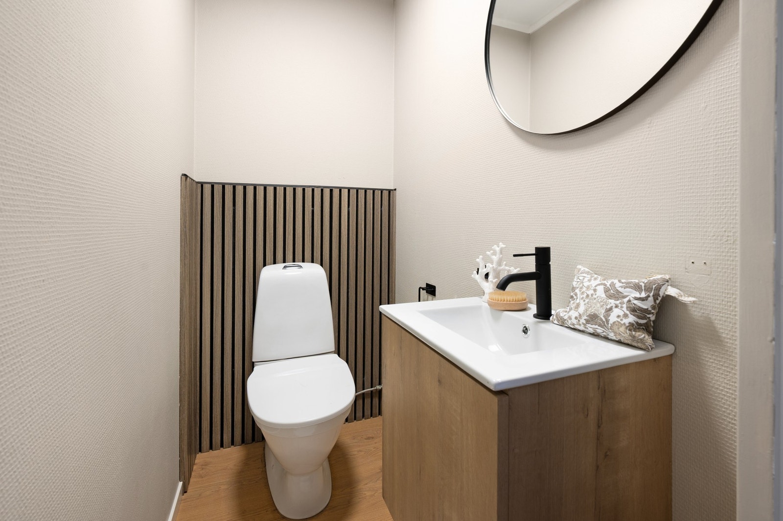 Toalettrommet er nylig oppusset med ny servant og overflater. Det er montert stilrene spiler bak WC, noe som tilfører rommet et eksklusivt uttrykk og gir en varm, moderne atmosfære. Galleribilde