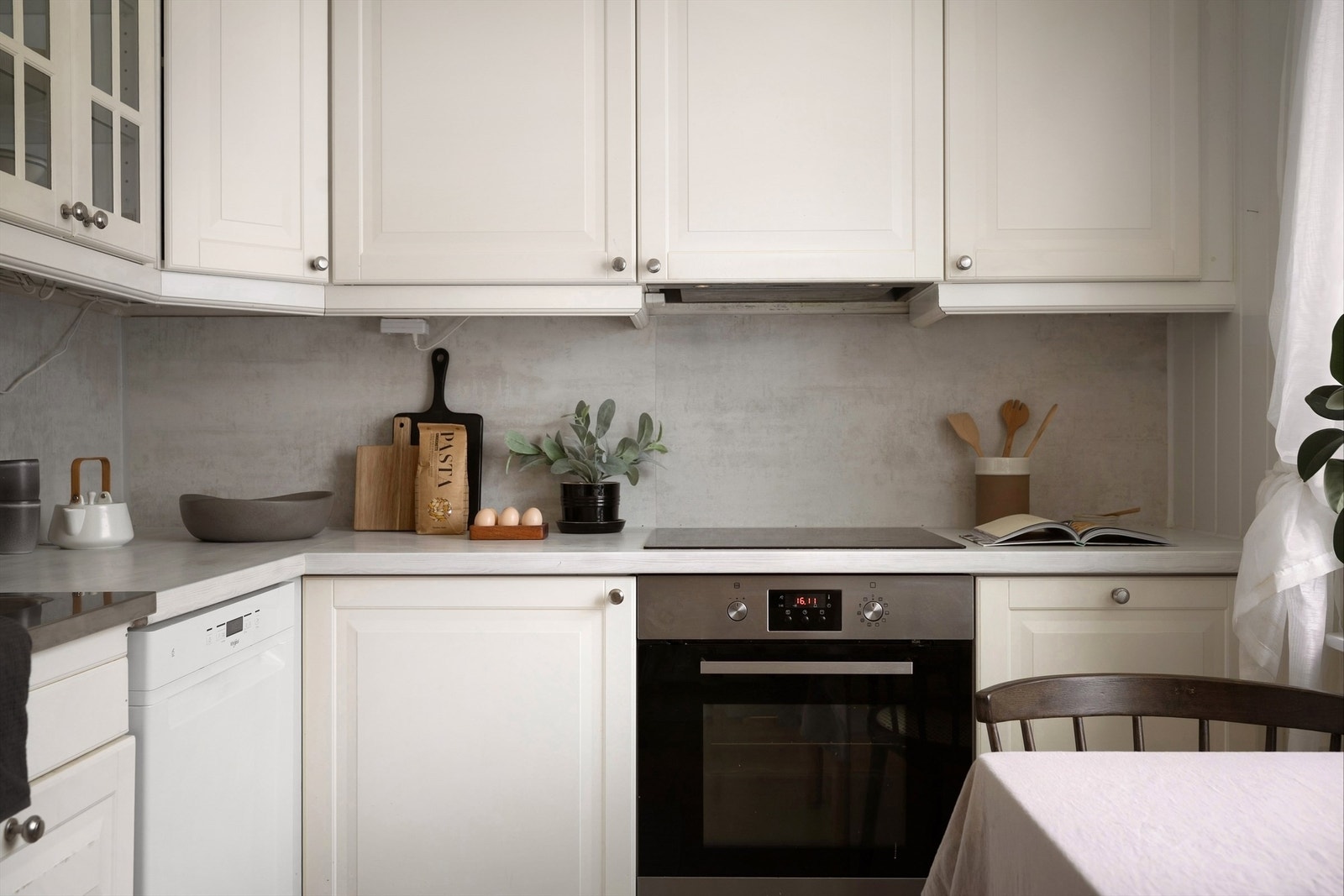 Kjøkkeninnredningen består av profilerte fronter, overskap med belysning, laminert benkeplate med oppvaskkum og ett-greps blandebatteri og platekledning over benkeplate. Galleribilde