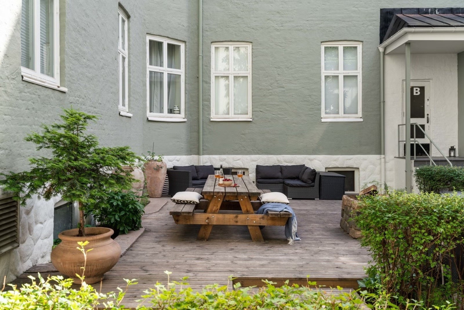 Bakgården er opparbeidet med lav hekk, felles terrasse og utemøblement, og har innmurt grill. Galleribilde