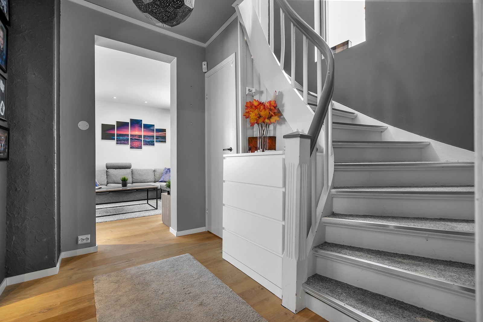 Videre kommer man inn i en gang som har gjennomgående parkettgulv til stue og kjøkken. Fra gangen har man trapp til 2. etasje (loftsetasjen) og til kjeller. Galleribilde