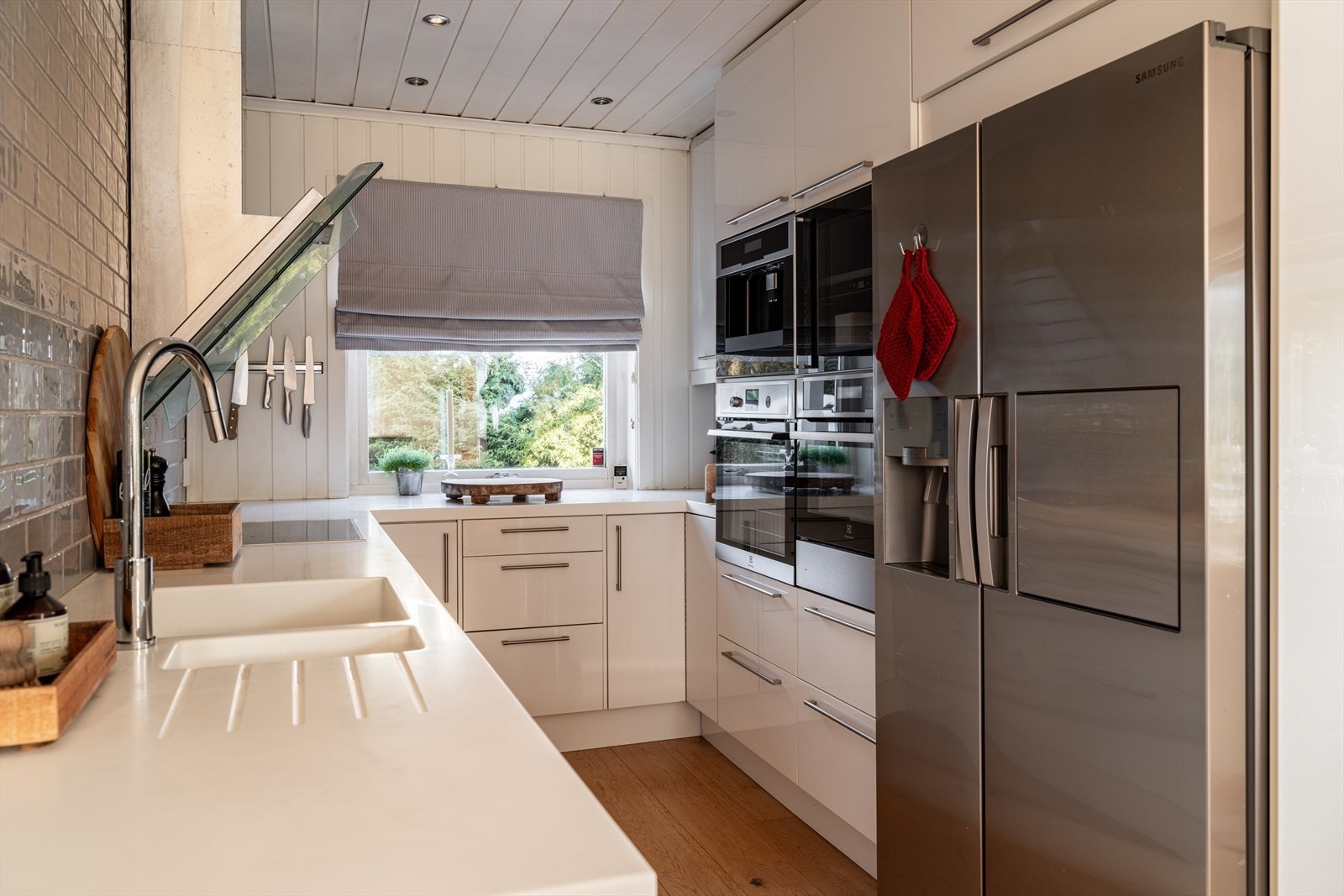 tstyrt med side-by-side kjøl/fryseskap, oppvaskmaskin, platetopp, vinskap, kaffemaskin, varmeskuff og to stekeovner. Galleribilde