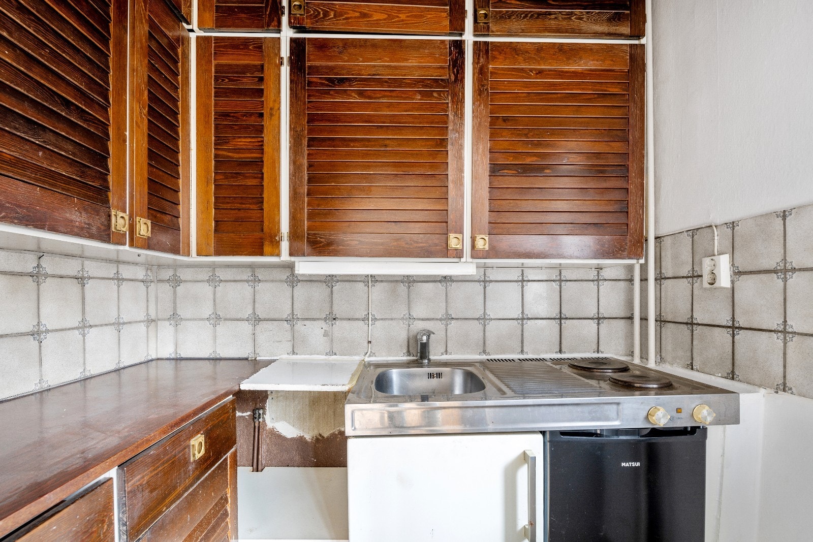 Kjøkkenkrok med koketopp og lite kjøleskap Galleribilde