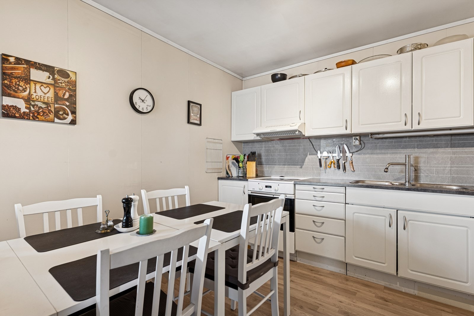 Kjøkkenet er innredet med hvite, profilerte fronter og grå benkeplate i laminat. Kjøkkenet er ellers utstyrt med frittstående hvitevarer og kjøkkenventilator med kullfilter/omluft. Galleribilde