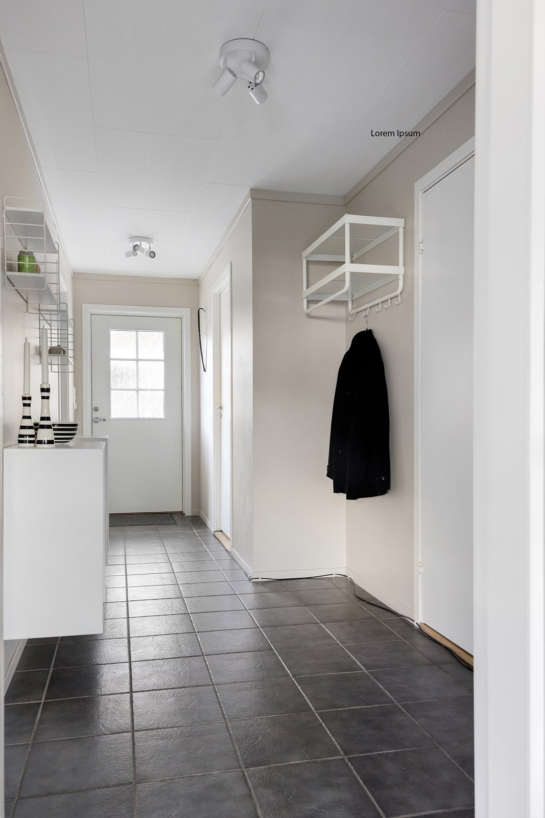 En lys og luftig entré ønsker deg velkommen inn. Her er det fliser på gulvet med varmekabler som gir en lun følelse året rundt. Det er rikelig med plass til oppbevaring av yttertøy og sko. Galleribilde